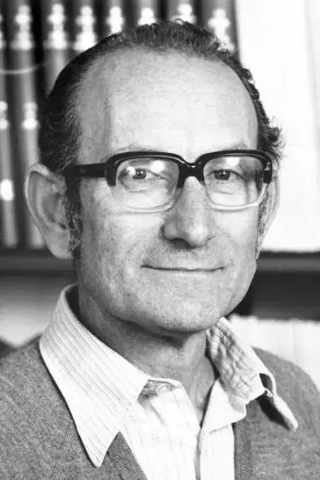 Fotografía retrato en blanco y negro de hombre sonriente con anteojos.