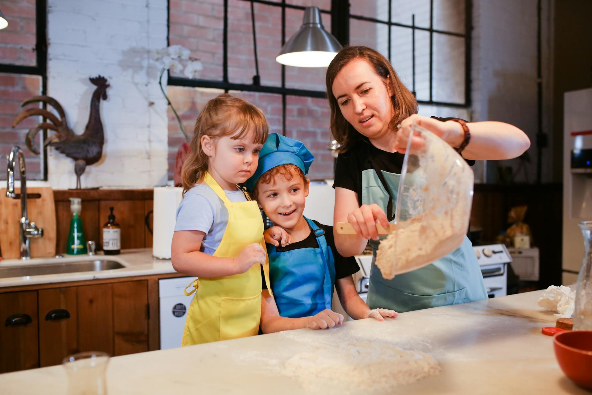 Adulta y niños cocinando en la cocina.