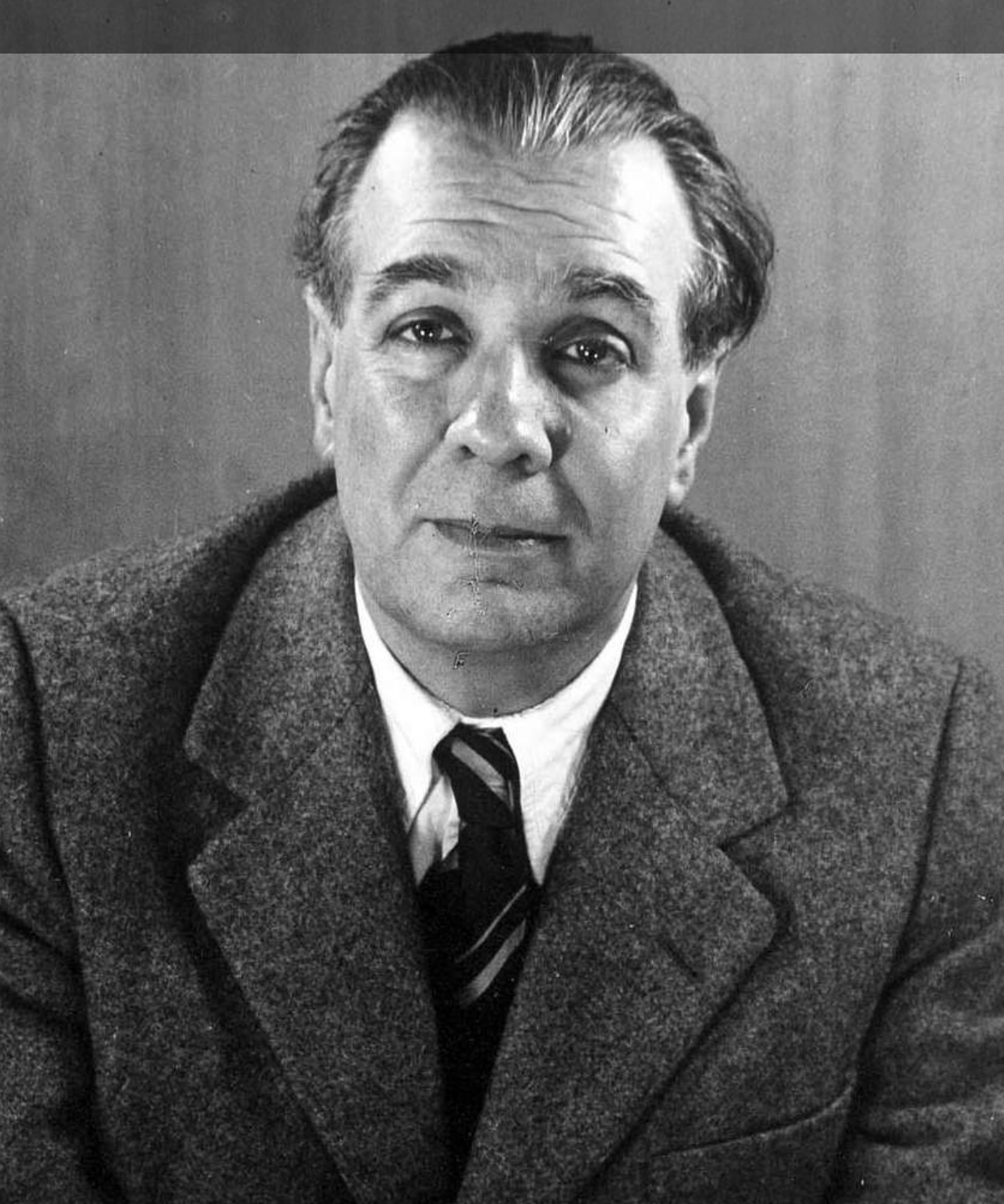 Retrato en blanco y negro de Jorge Luis Borges en 1951, escritor argentino con traje y corbata, fotografía de Grete Stern