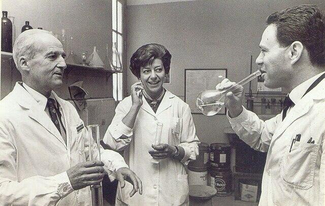 Dos hombres y una mujer con delantal blanco en el laboratorio.