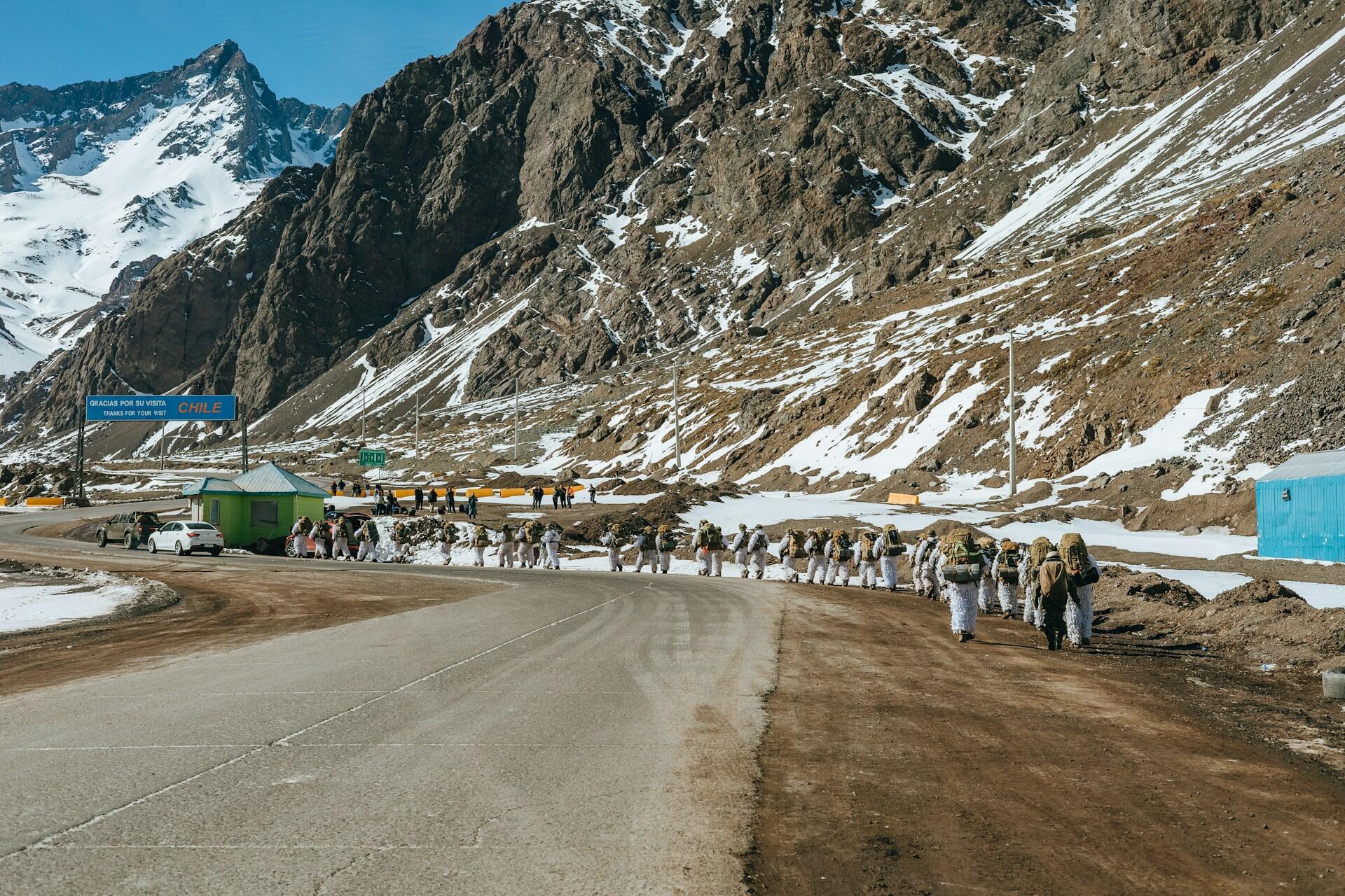 Grupo de soldados con camuflaje de nieve marcha por una ruta en un paso fronterizo de Chile. Fotografía de Rafael Rodrigues.