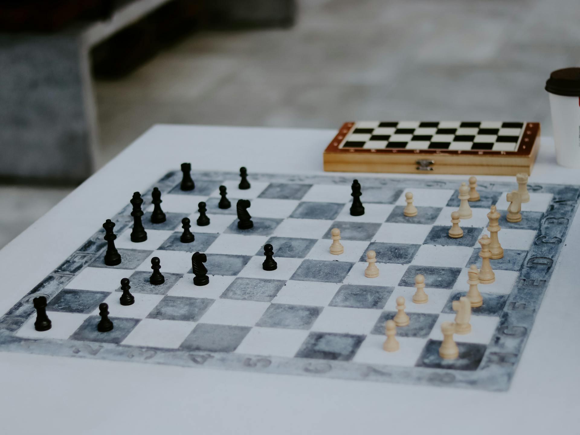 Tablero de ajedrez con casilleros blancos y negros y piezas encima.