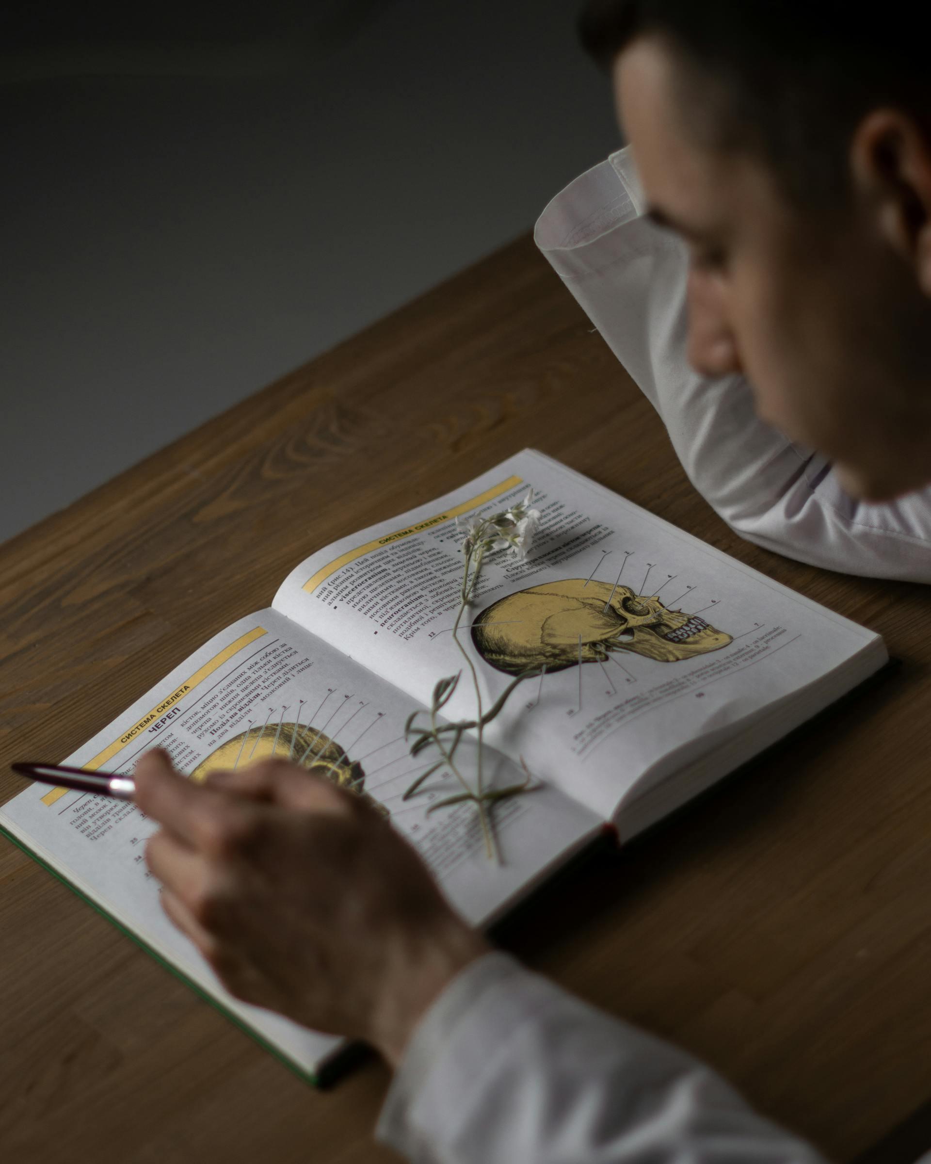 Joven leyendo libro de medicina.