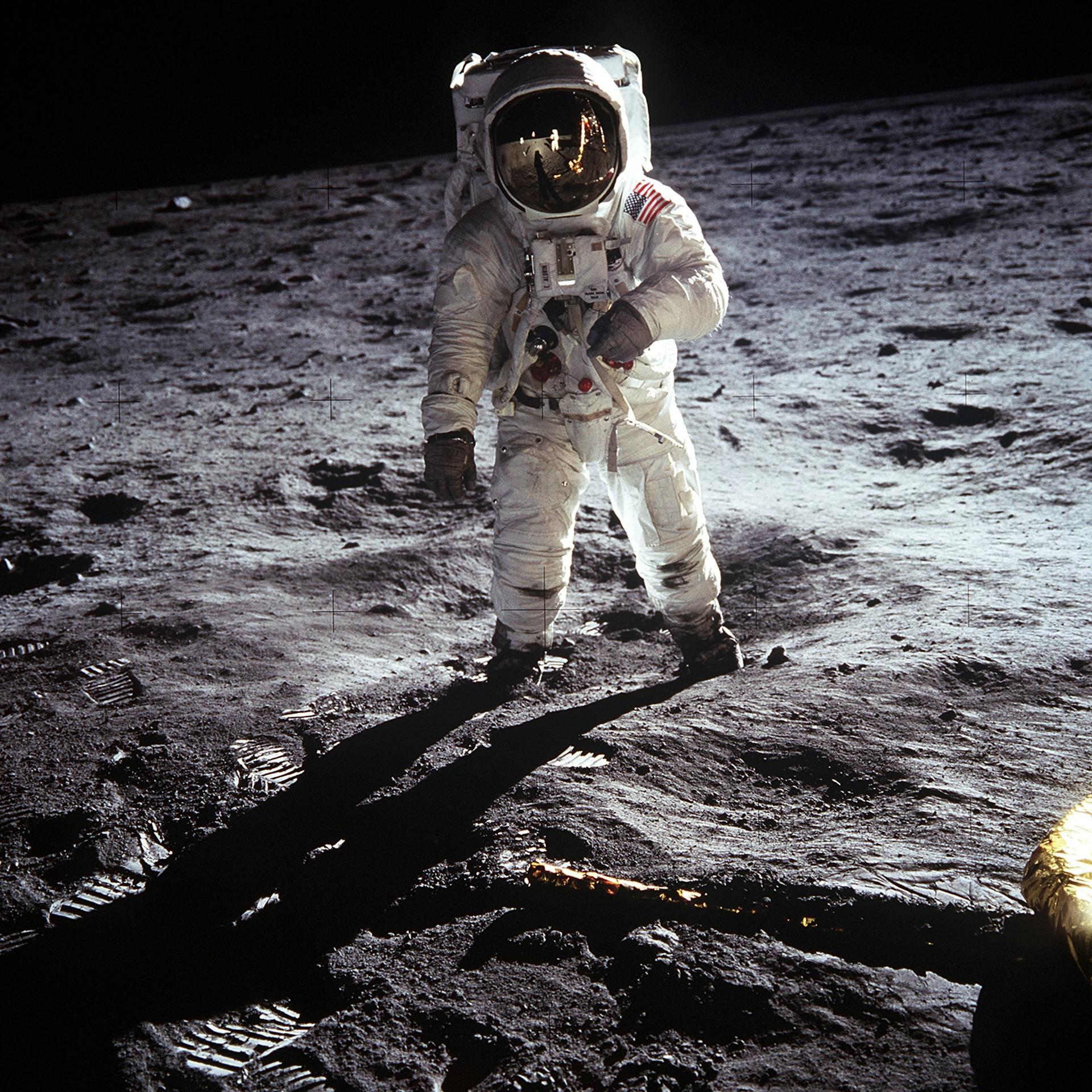 Hombre en traje de astronauta parado sobre estructura rocosa.