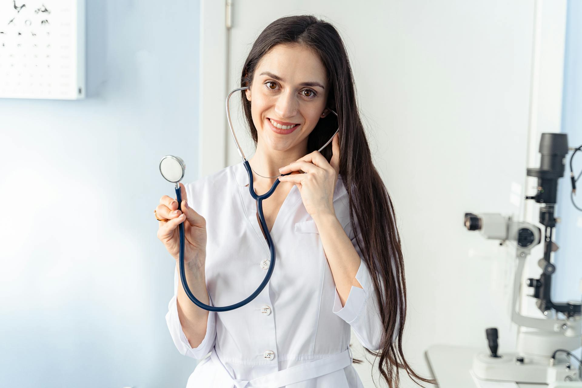 Mujer sonriente con delantal blanco sosteniendo un elemento médico.