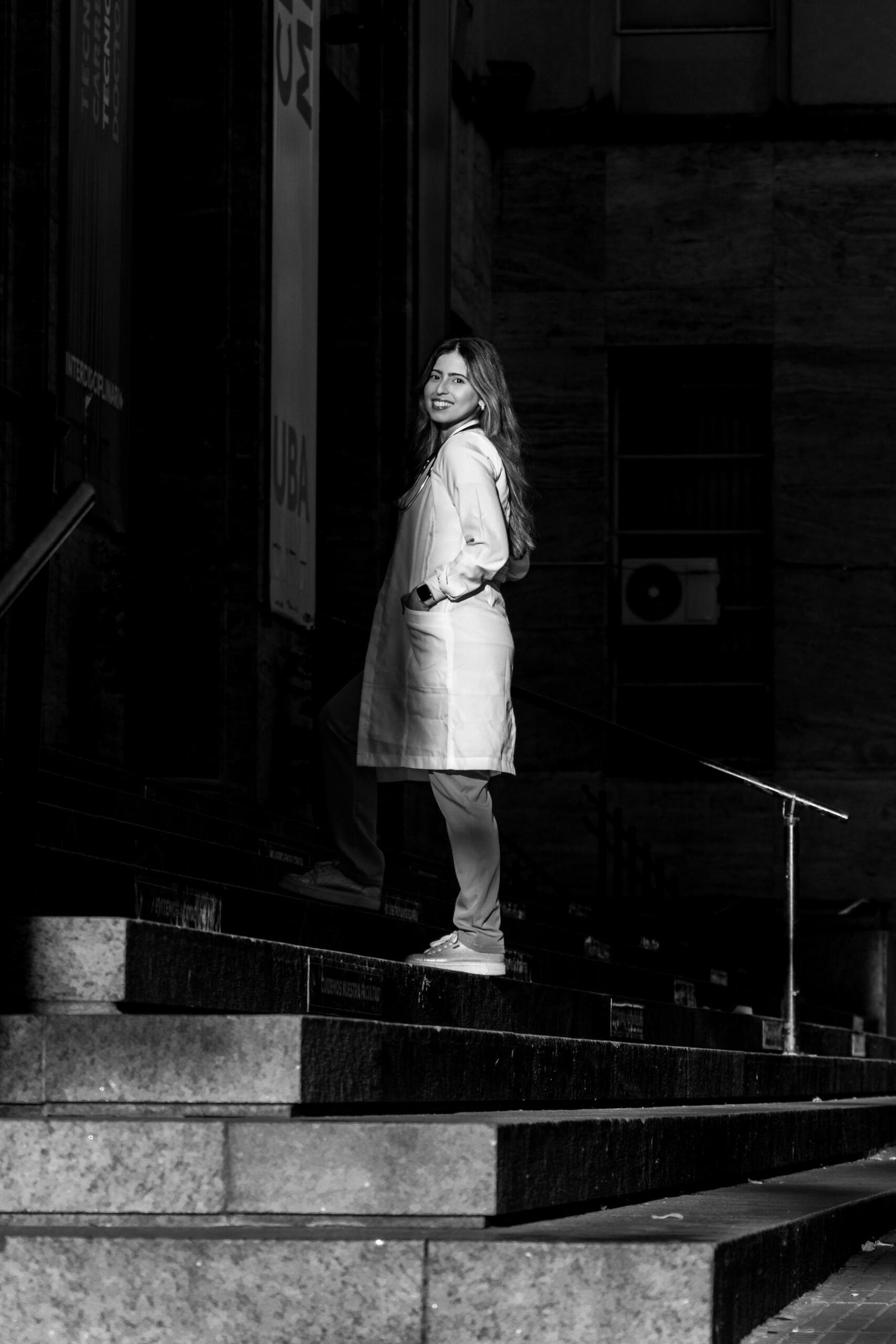 Mujer con delantal blanco parada en la escalera.