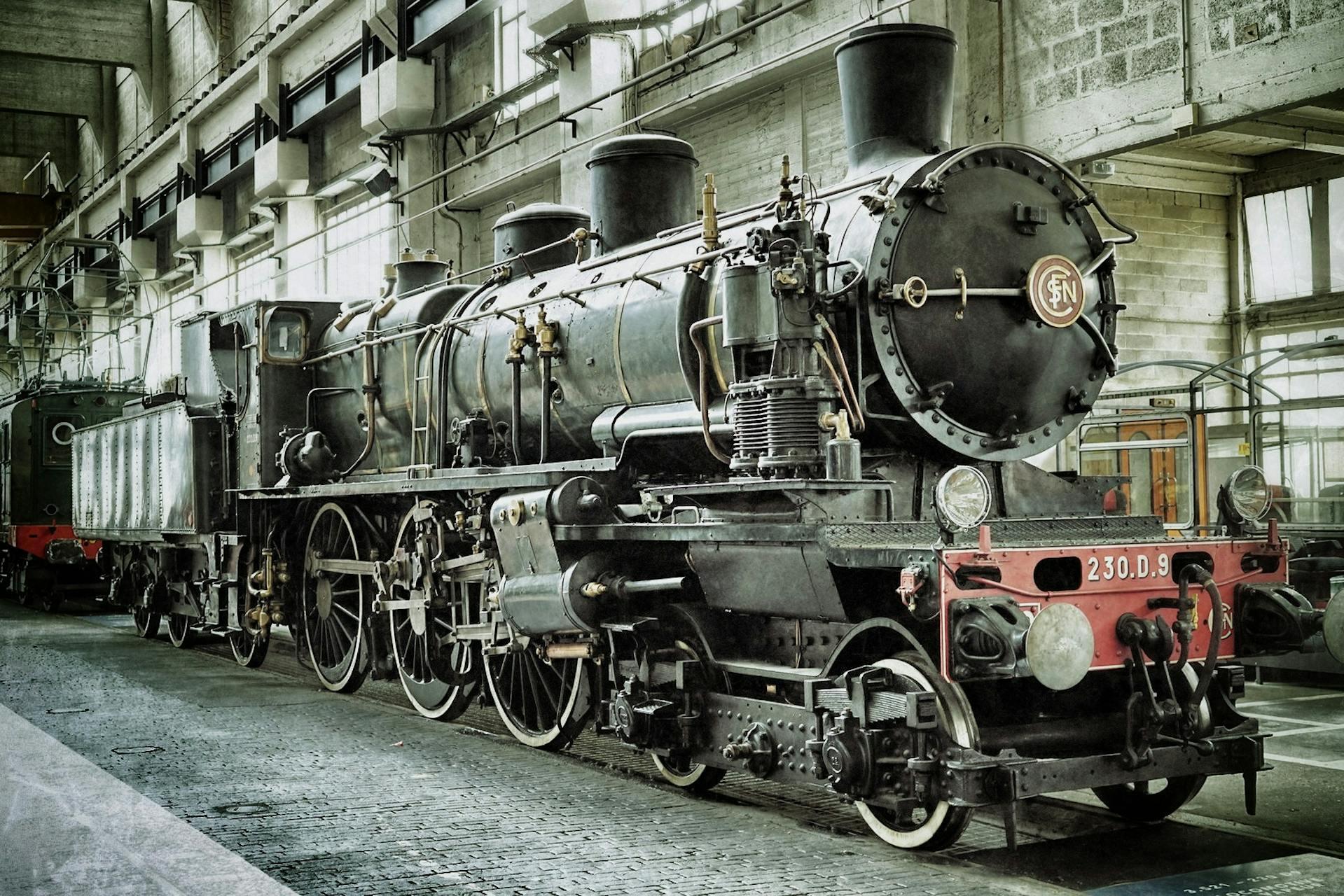 Ferrocarril antiguo dentro de la estación con paredes de cemento.
