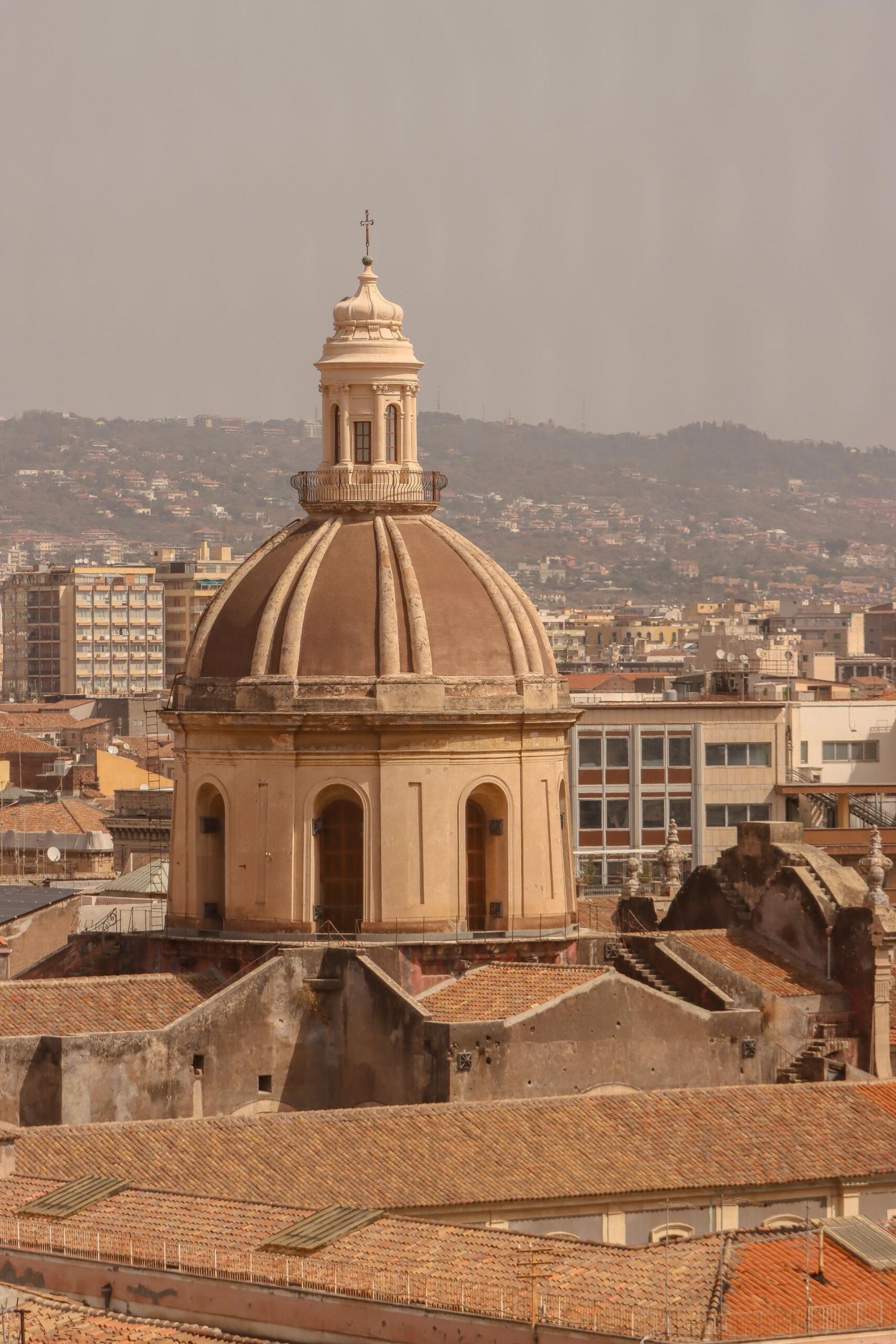 Cúpula de iglesia en la ciudad con fondo de montañas.