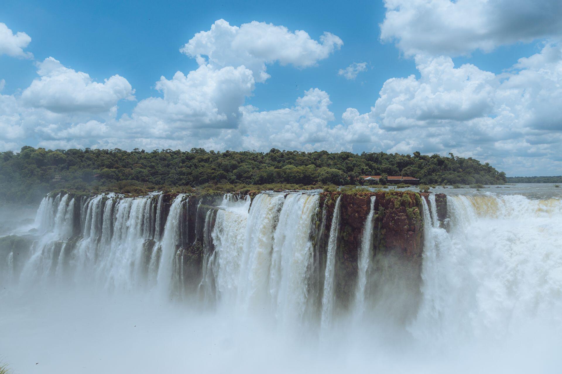 Cataratas del Iguazú, Provincia de Misiones, Argentina. Vista panorámica de los saltos de agua bajo un cielo con nubes blancas por Csaba Marosi.