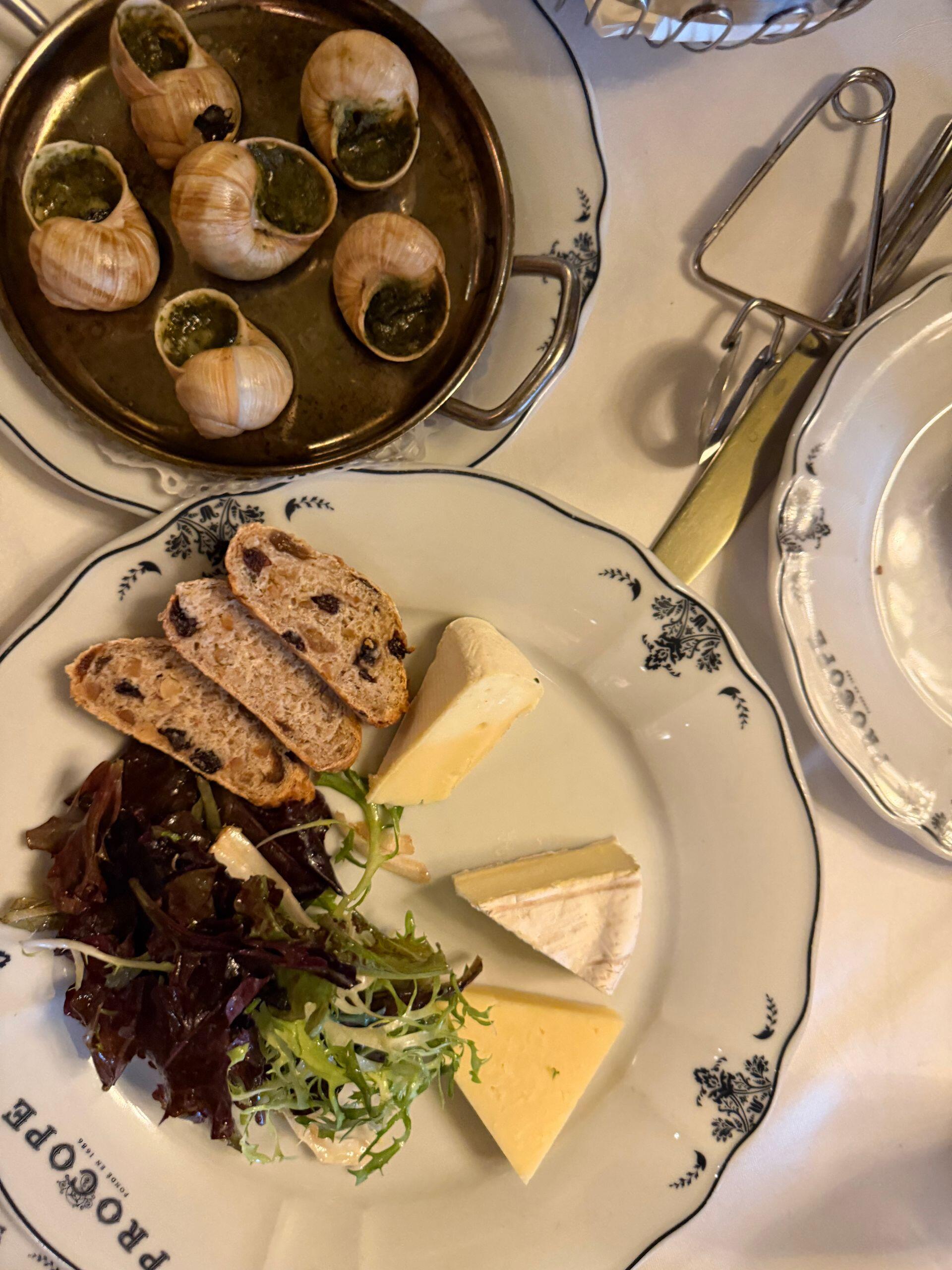 Plato con queso y pan y plato con caracoles.