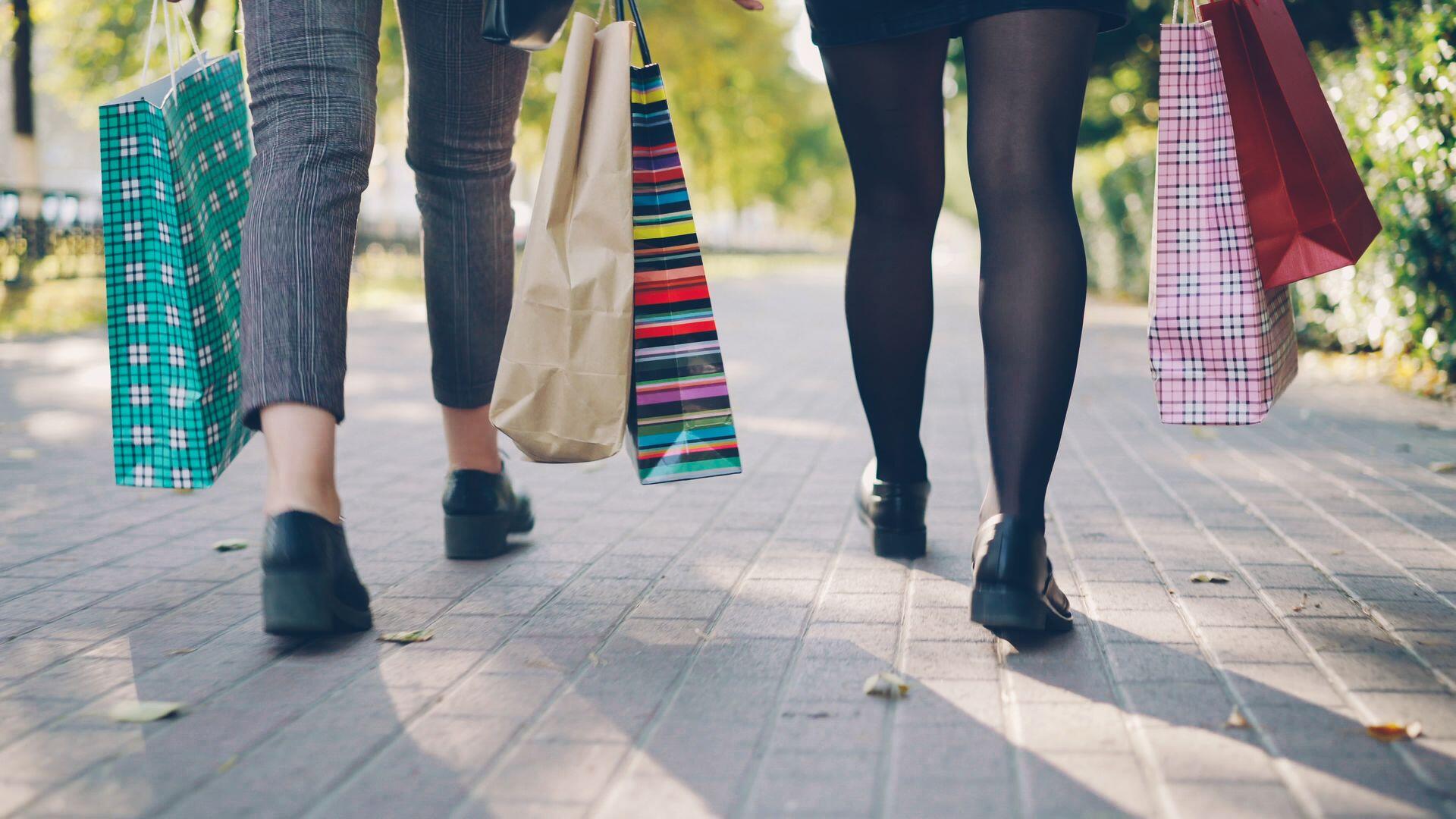 Piernas de mujeres con bolsas a los costados.