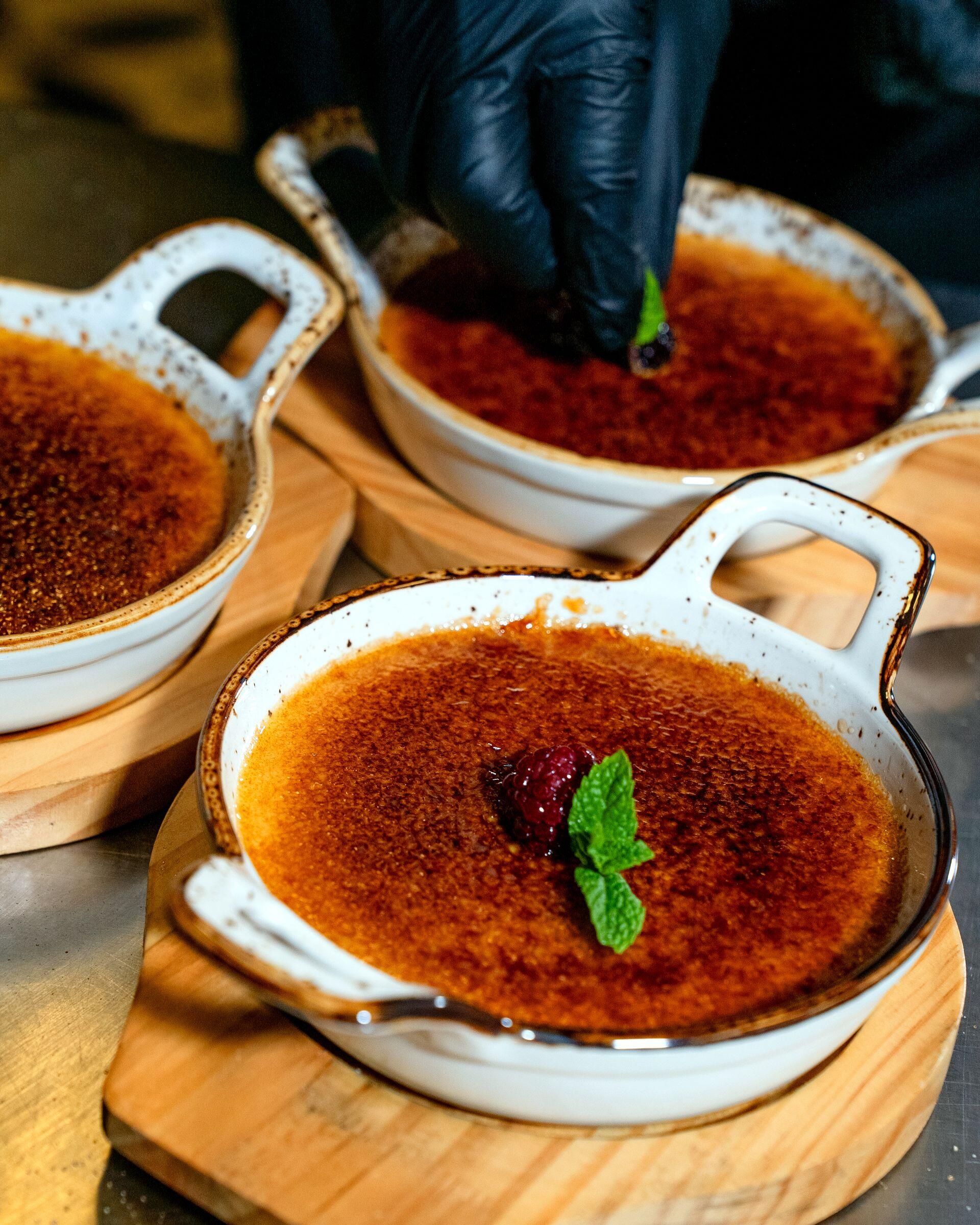 Postre gratinado servio en cuencos blancos con una hoja de menta encima.