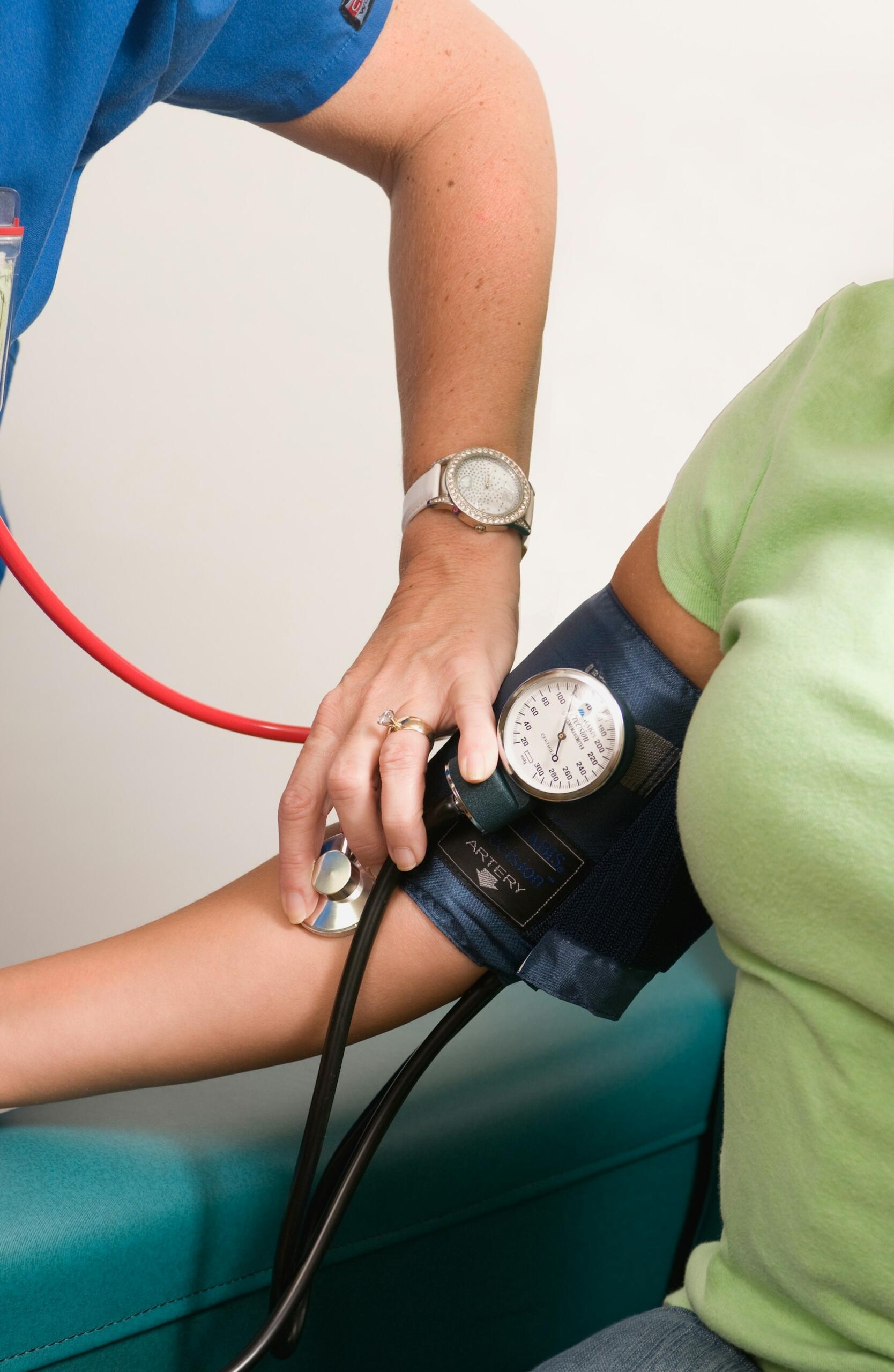Consultorio médico, profesional de salud realizando la toma de presión arterial a un paciente, fuente: CDC.