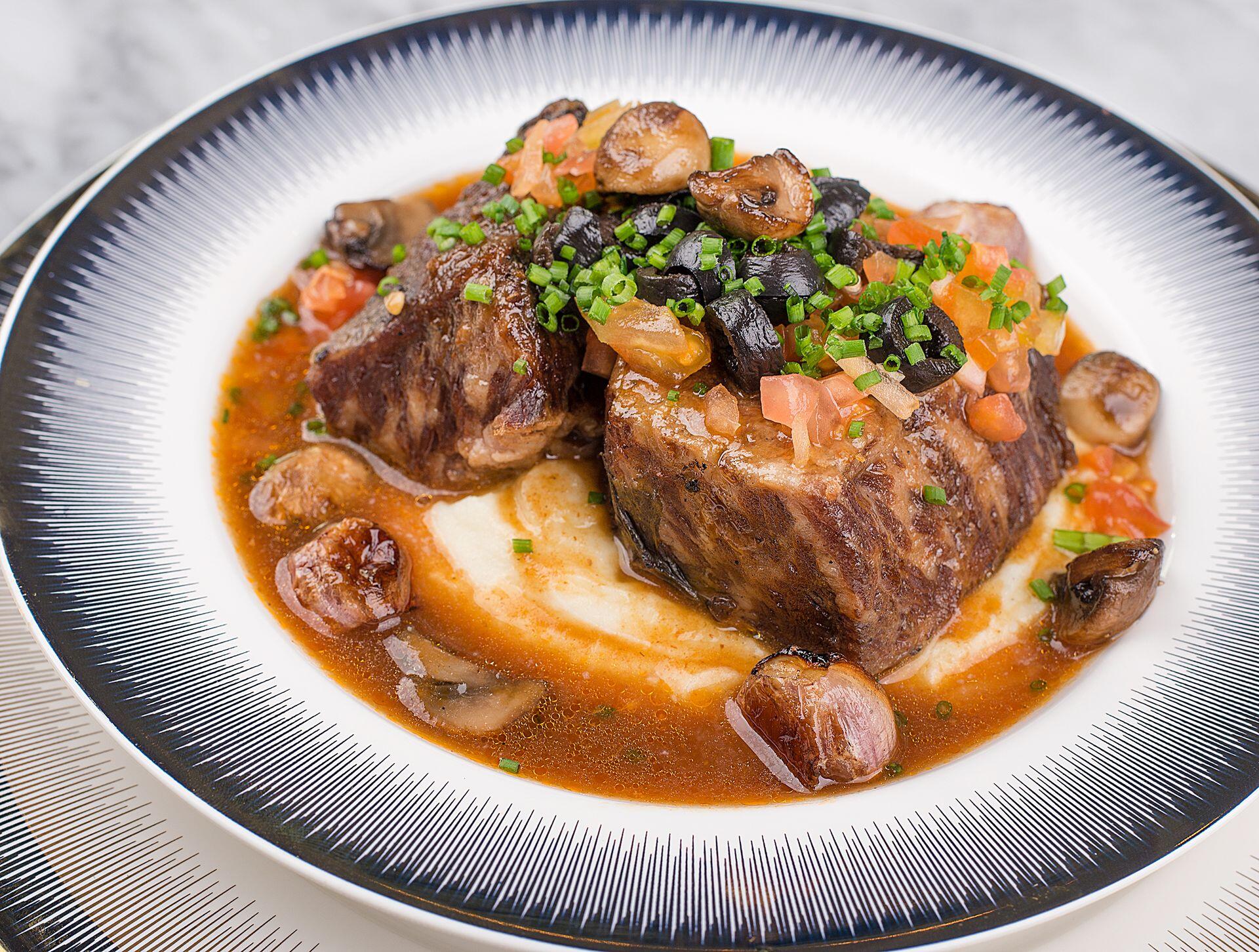 Plato de carne con puré y salsa de champignones.