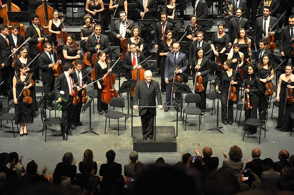 Musicos y directos de orquesta con instrumentos frente al público.