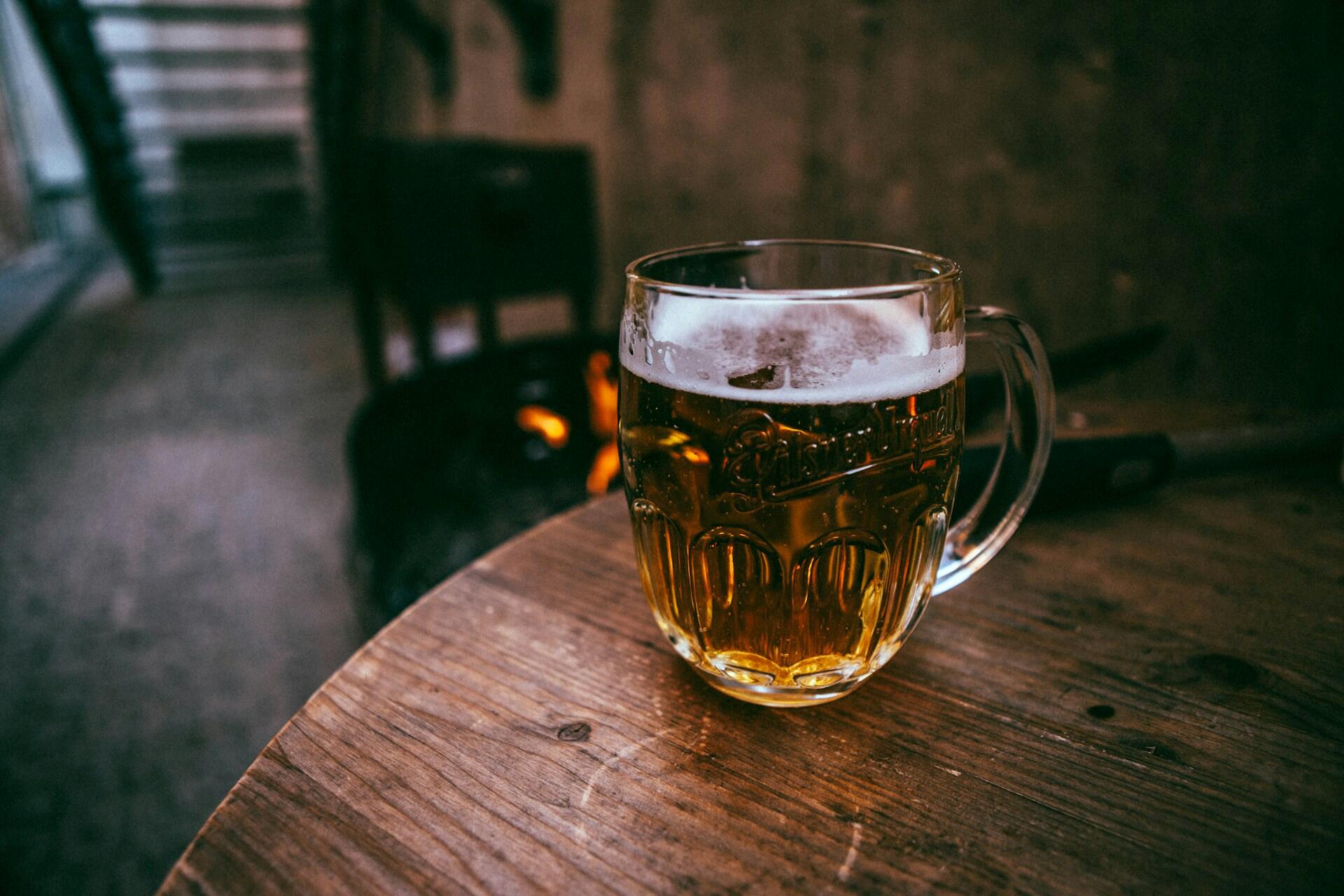 Mesa de madera, chopp de cerveza artesanal servido, Evgeniy Smersh / Unsplash.