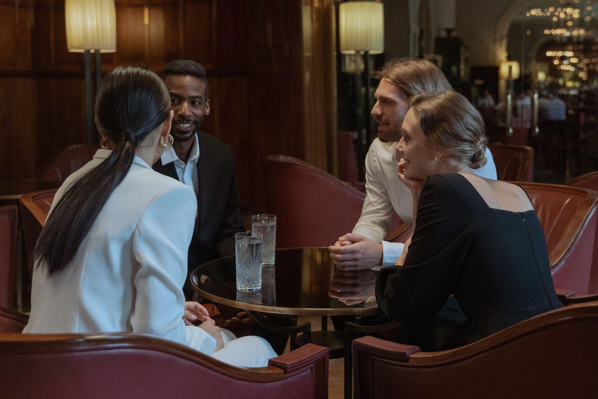 Dos hombres y dos mujeres conversando en el bar.