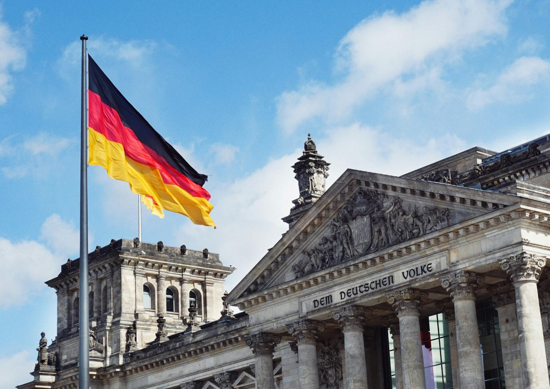Berlín, Alemania. Bandera alemana flameando frente al edificio del Reichstag, por Maheshkumar Painam.
