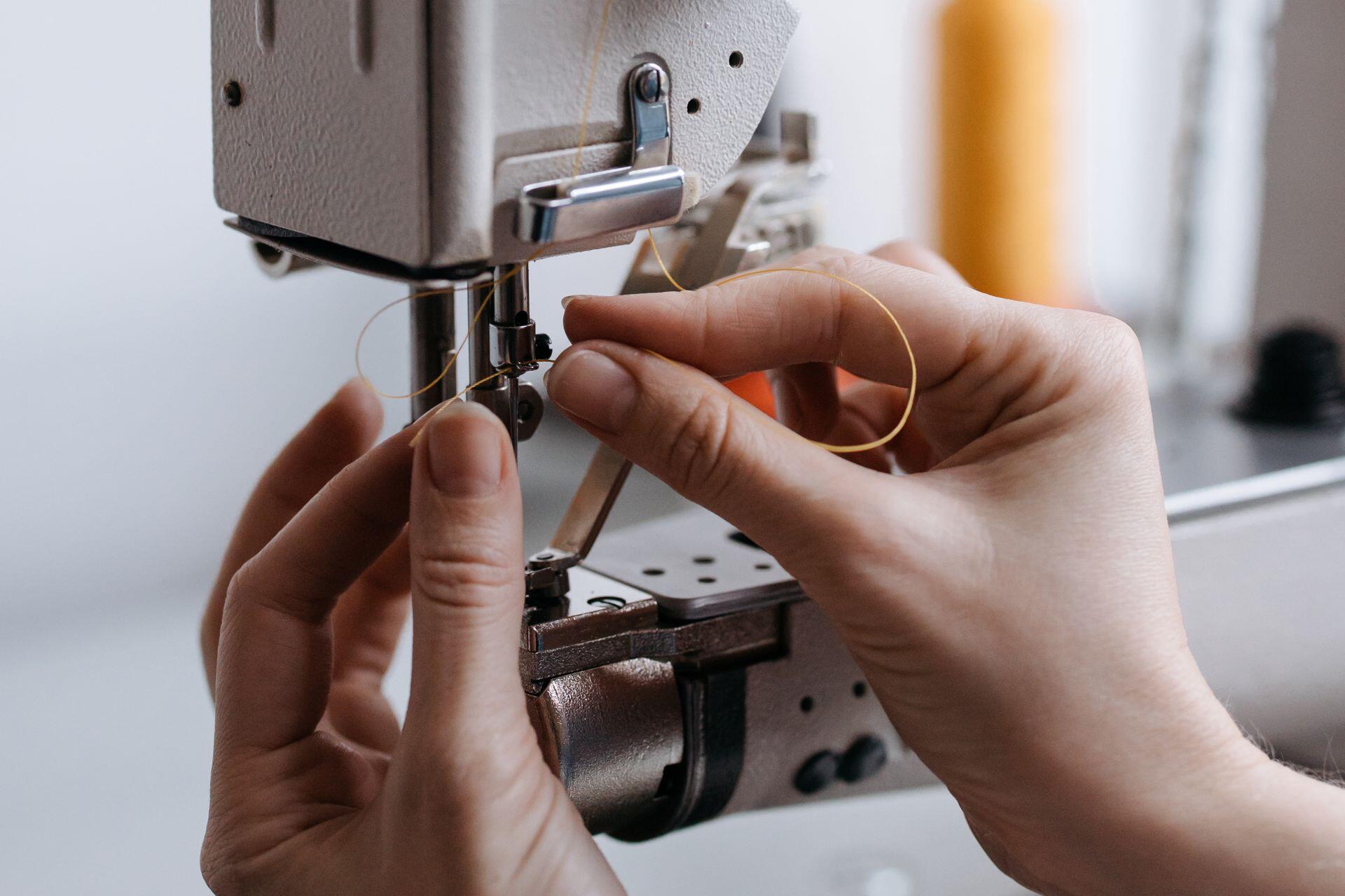 Acomodando el hilo en la máquina de coser.