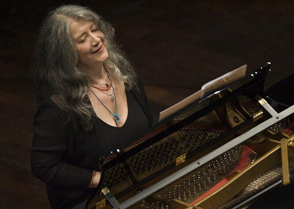 Mujer vestida de negro tocando el piano.