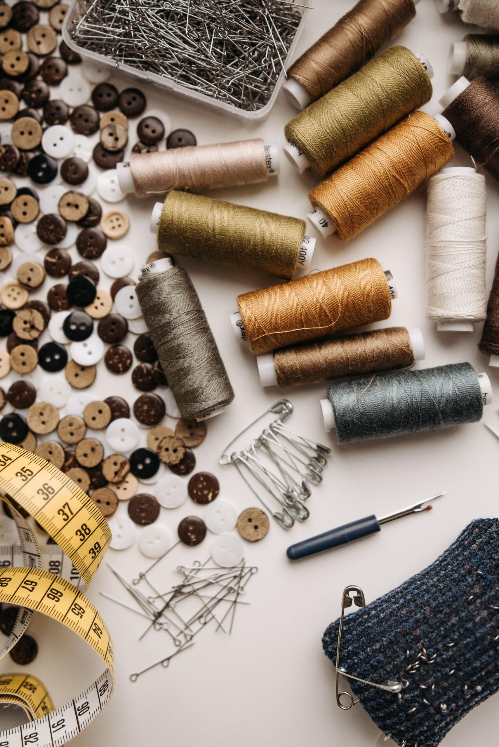 Hilos, aguja, alfileres, cinta métrica y otros materiales de costura.