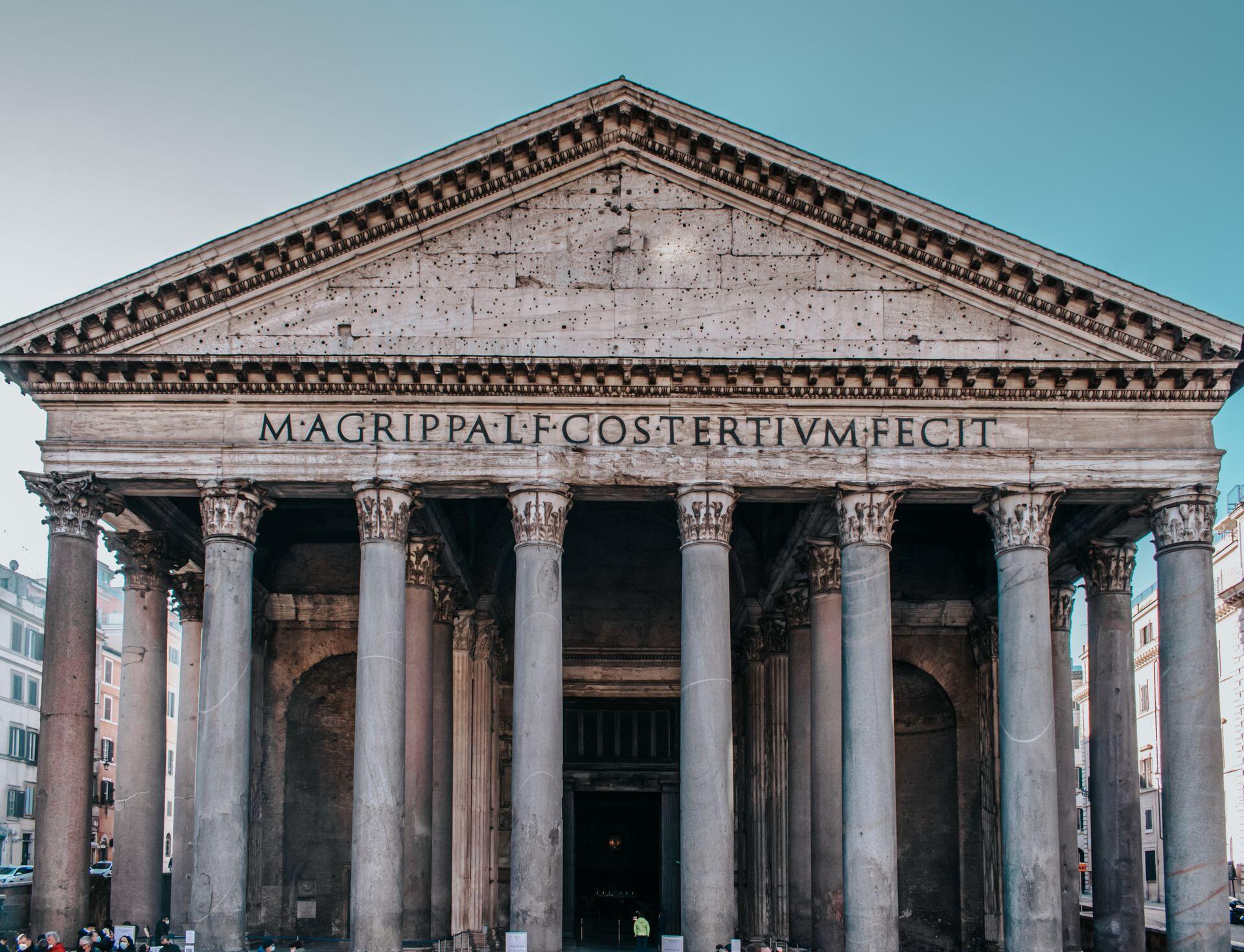 Edificio romano con columnas y escritura en latín.