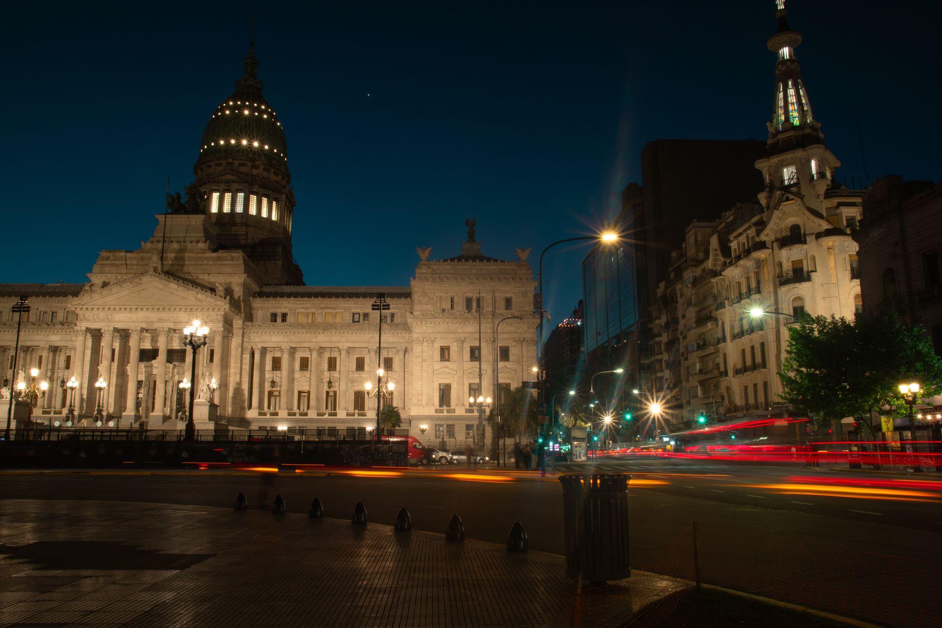 Edificio antiguo con cúpula iluminado al anochecer.