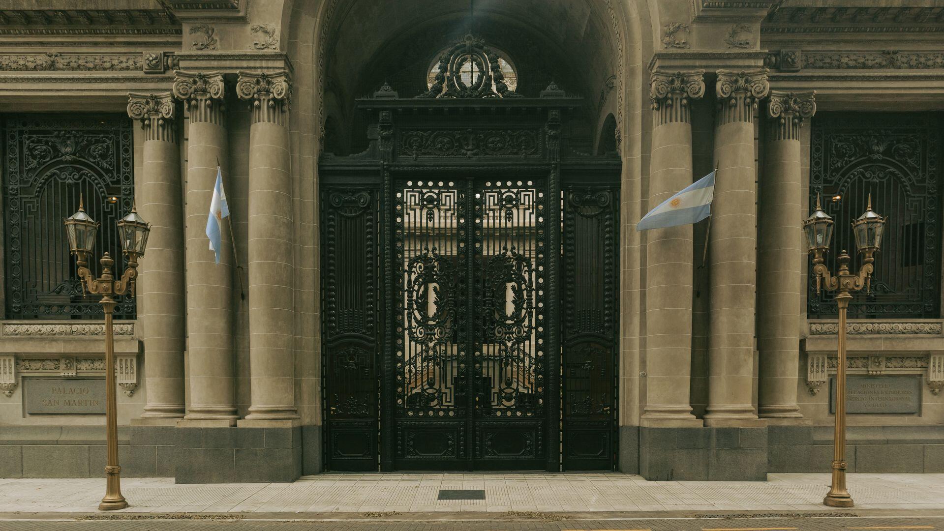 Entrada de edifico antiguo con ornamentos y baderas.