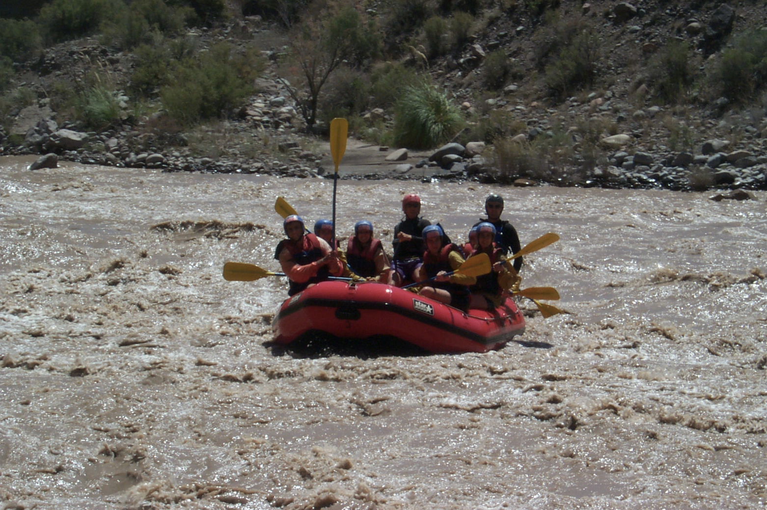 Río Mendoza, Mendoza: Grupo de personas practicando rafting en un bote rojo sobre los rápidos. Fuente: Wiki Commons.