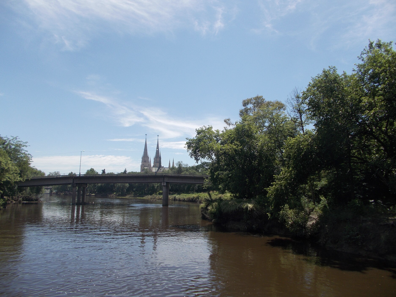 Río Luján, Buenos Aires: Puente sobre el río con las torres de la Basílica de Luján asomando al fondo. Fuente: Wiki Commons.
