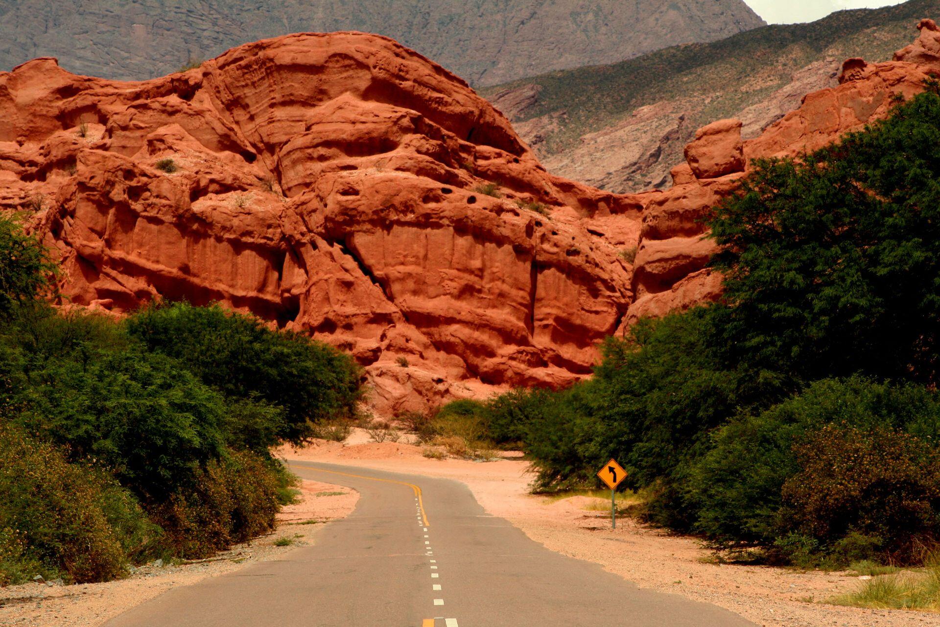 Camino de ruta entre las formaciones rocosas anaranjadas.