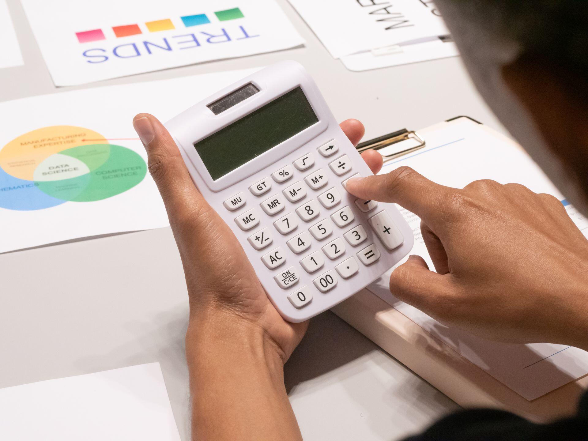 Manos apoyadas sobre las teclas de la calculadora.