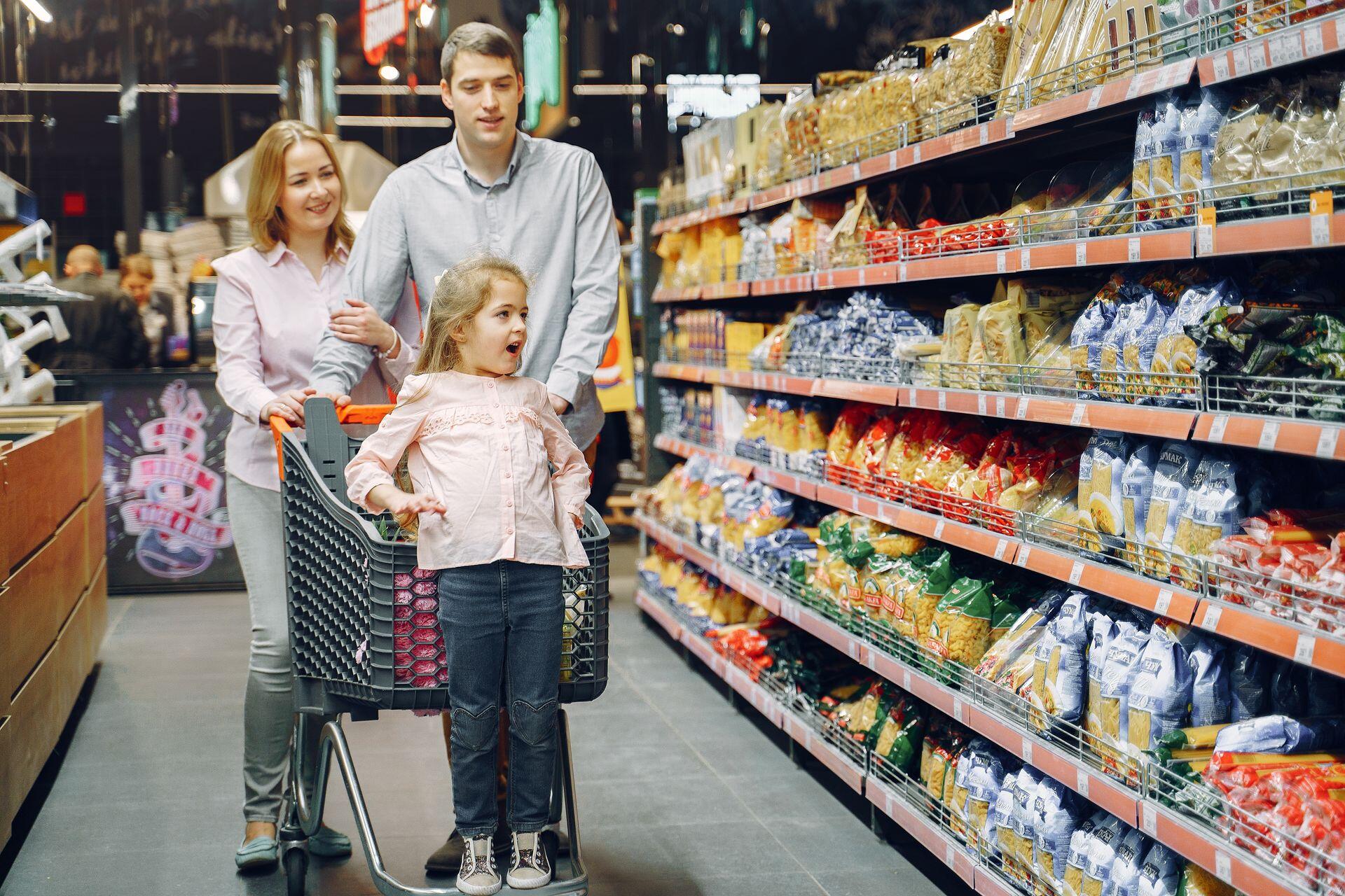 Familia haciendo compras con el carrito de supermercado.