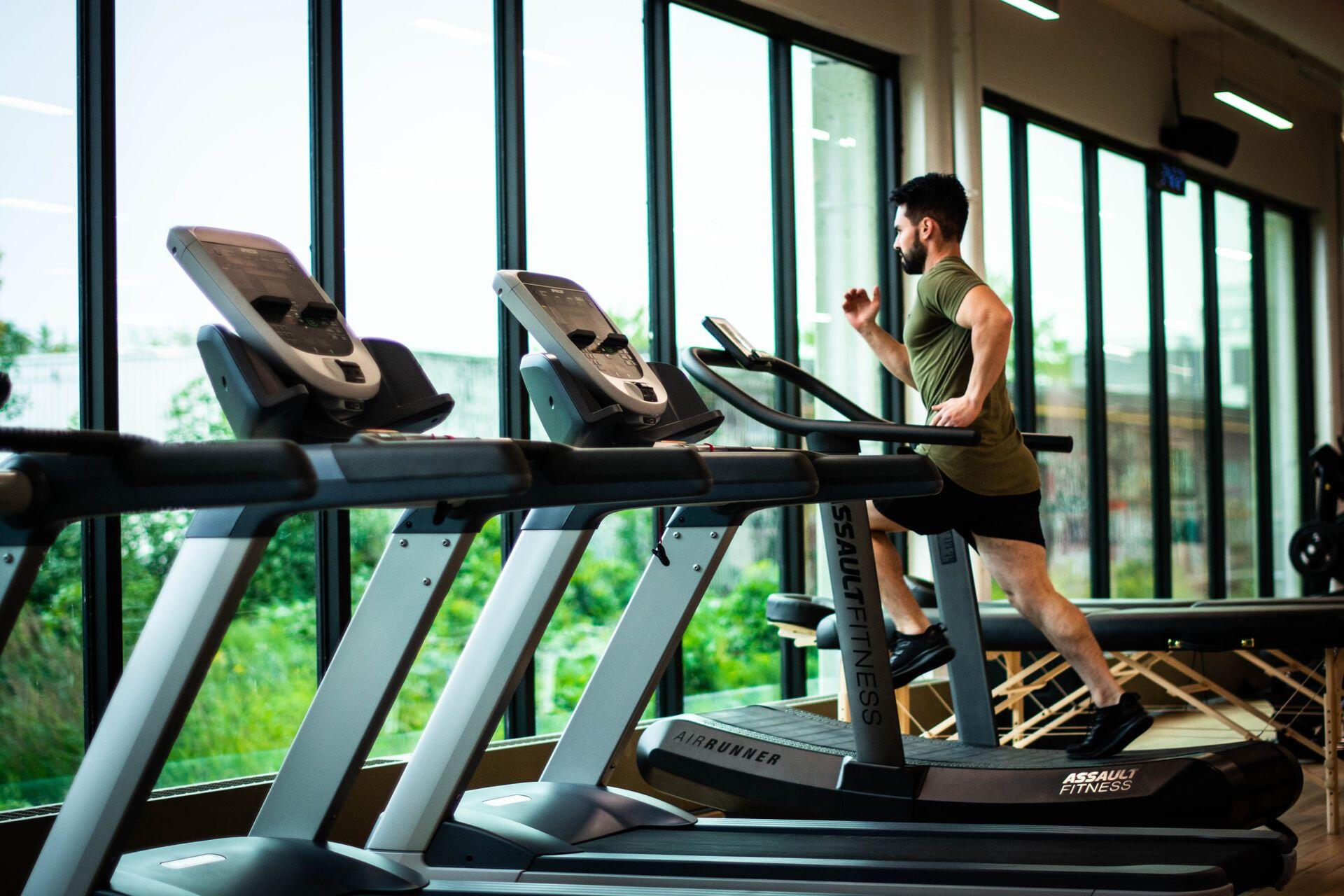 Hombre corriendo en la cinta del gimnasio.