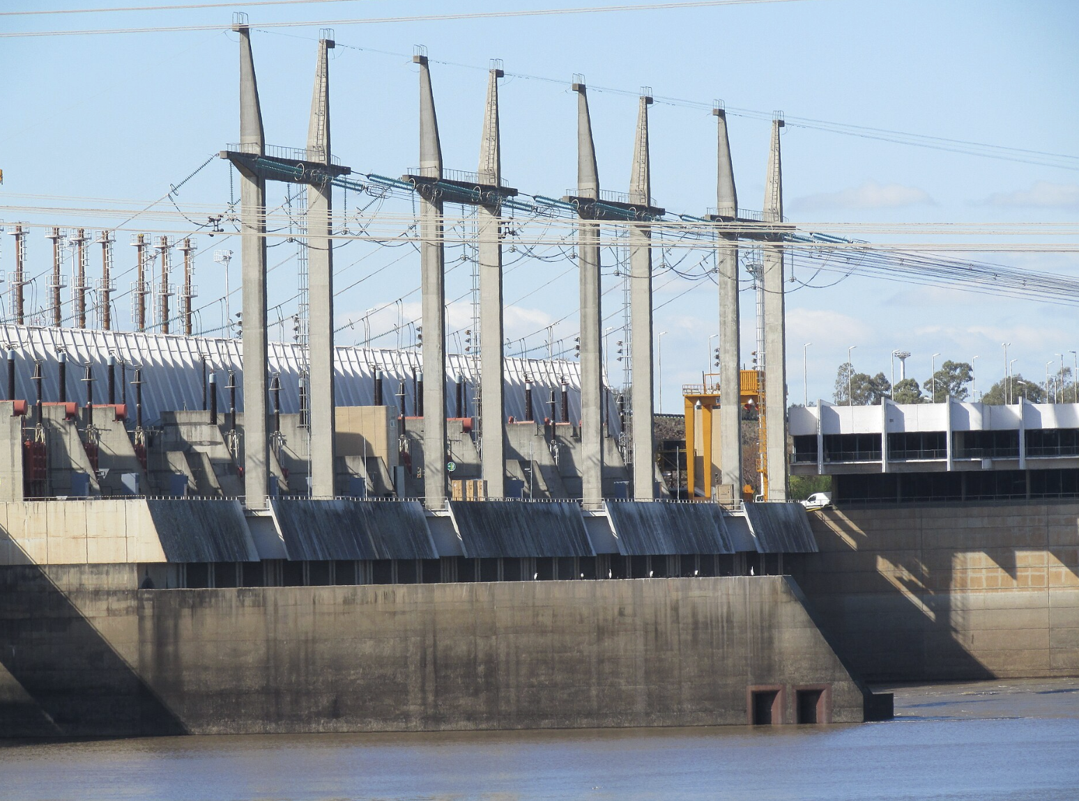 Represa de Salto Grande, lado uruguayo. Vista exterior de la zona de generadores y torres de alta tensión. Fuente: Wikimedia Commons.