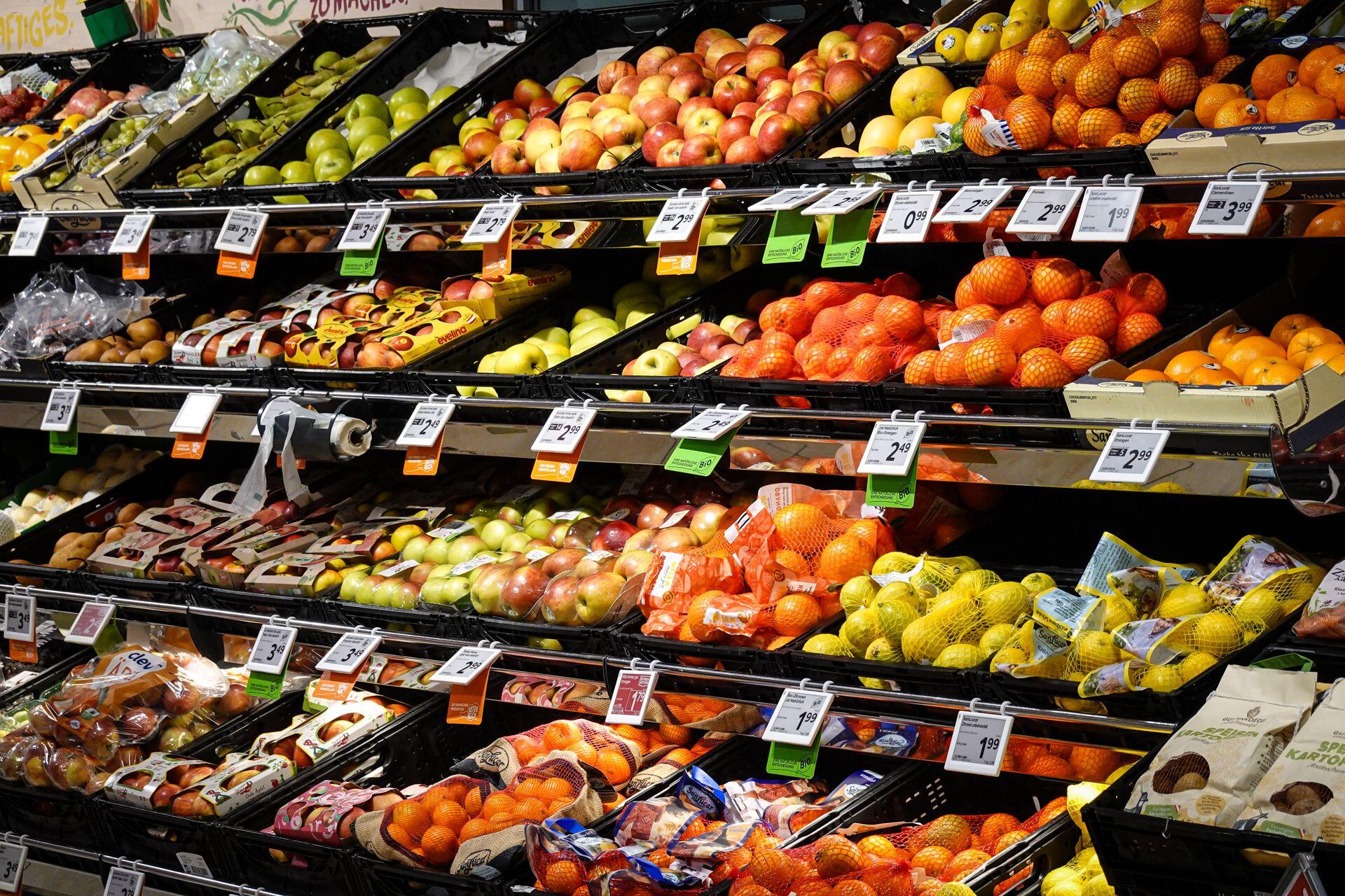 Gondola de frutas y verduras con carteles de precio.