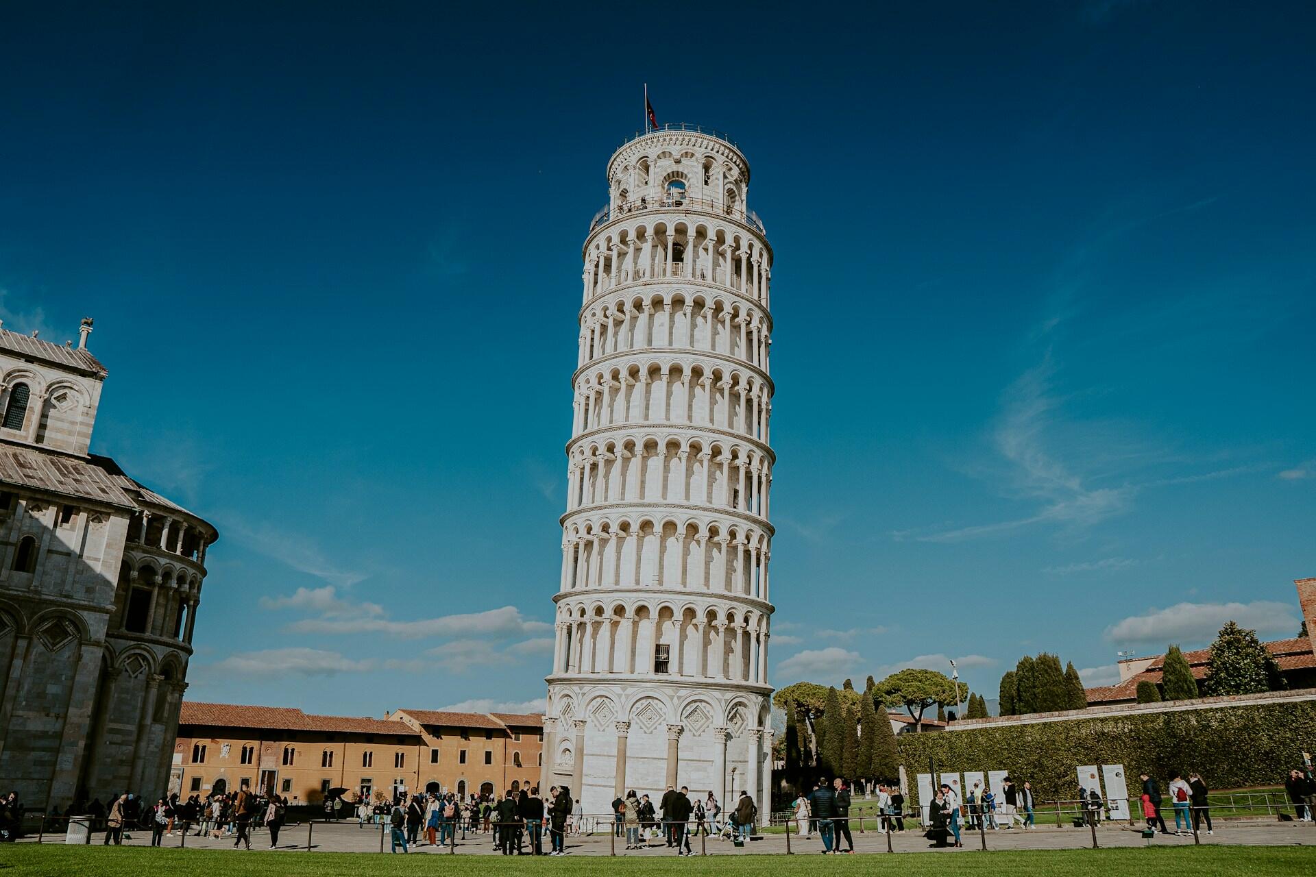 Torre de Pisa en la Piazza del Duomo, Pisa, Italia; la famosa torre campanario inclinada de mármol blanco bajo un cielo despejado. Fotógrafo: Angello Pro.