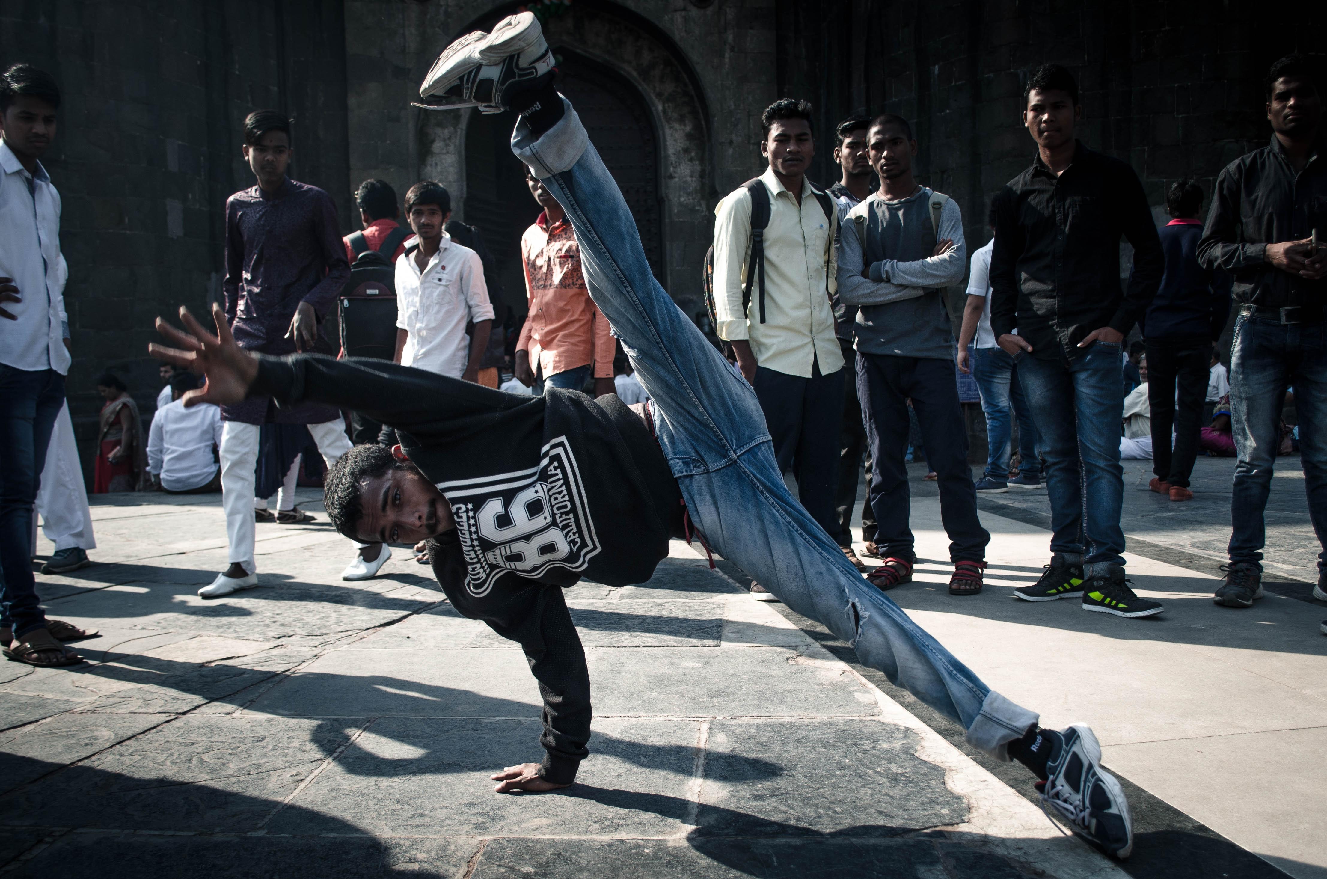 Ein Mann tanzt Breakdance auf der Straße.