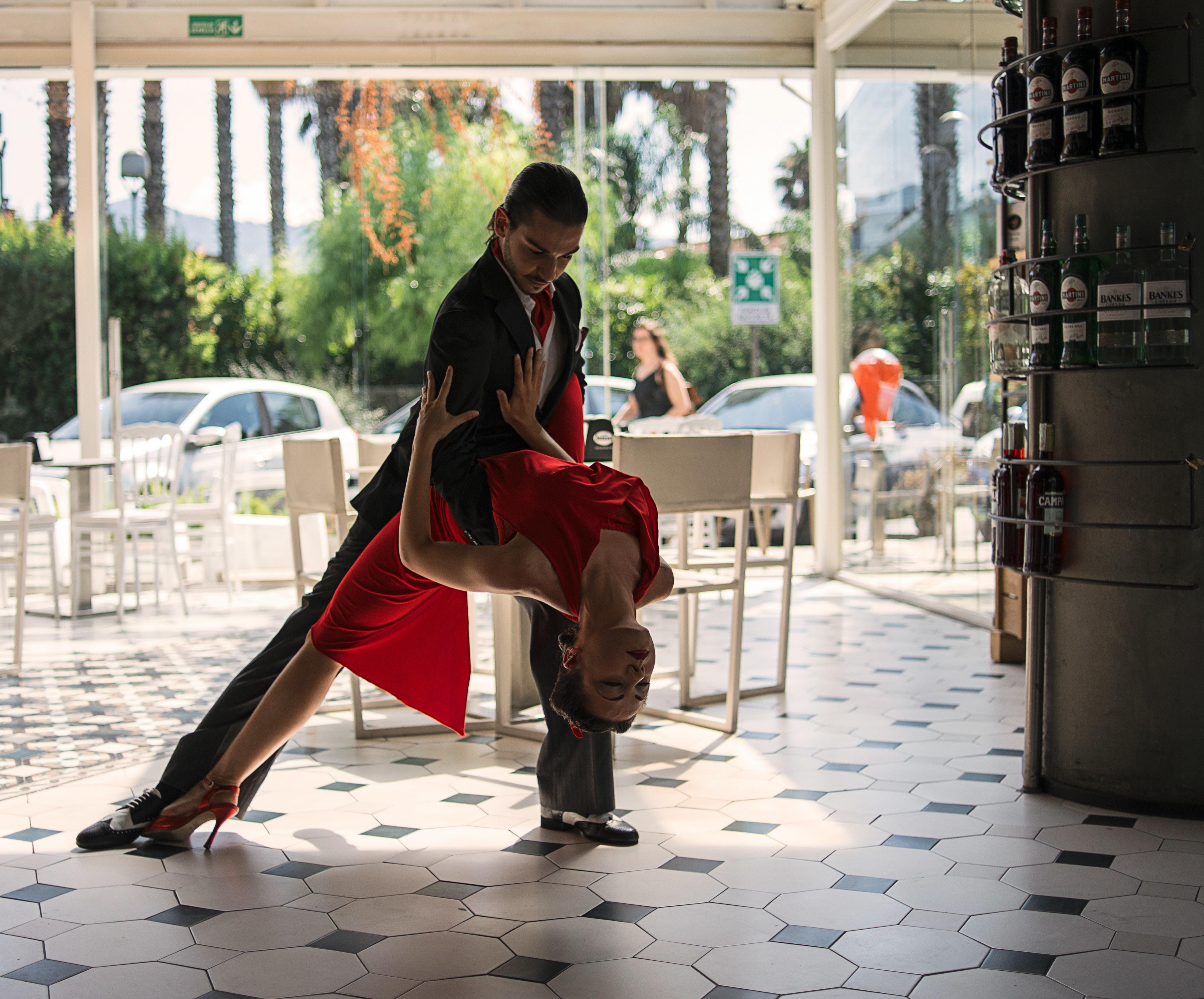 Eine Frau und ein Mann tanzen gemeinsam in einem Cafe. 