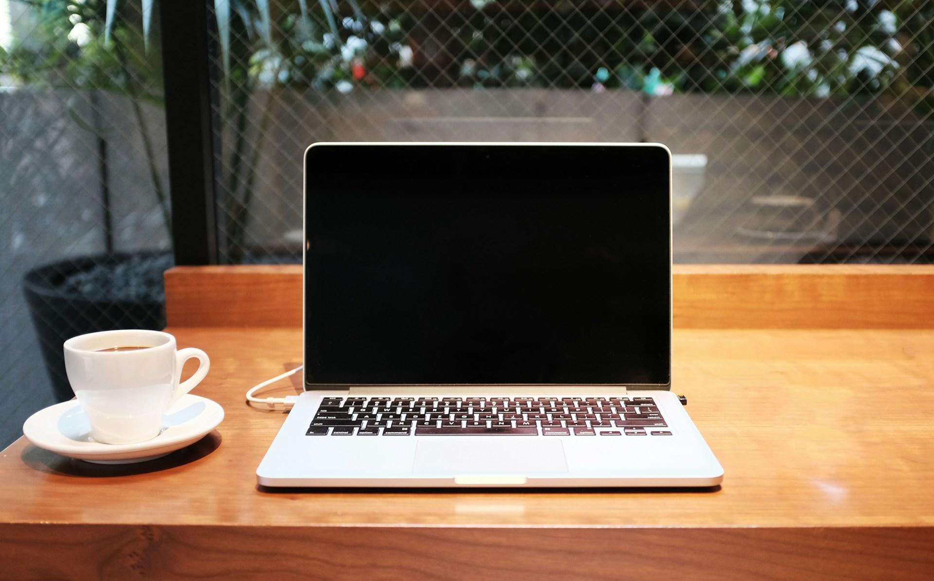 Laptop mit Kaffeetasse auf einem Tisch