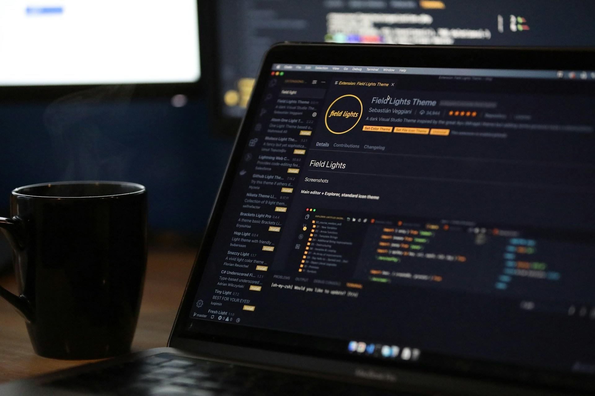 Computer mit Programmierprogramm und Kaffeetasse
