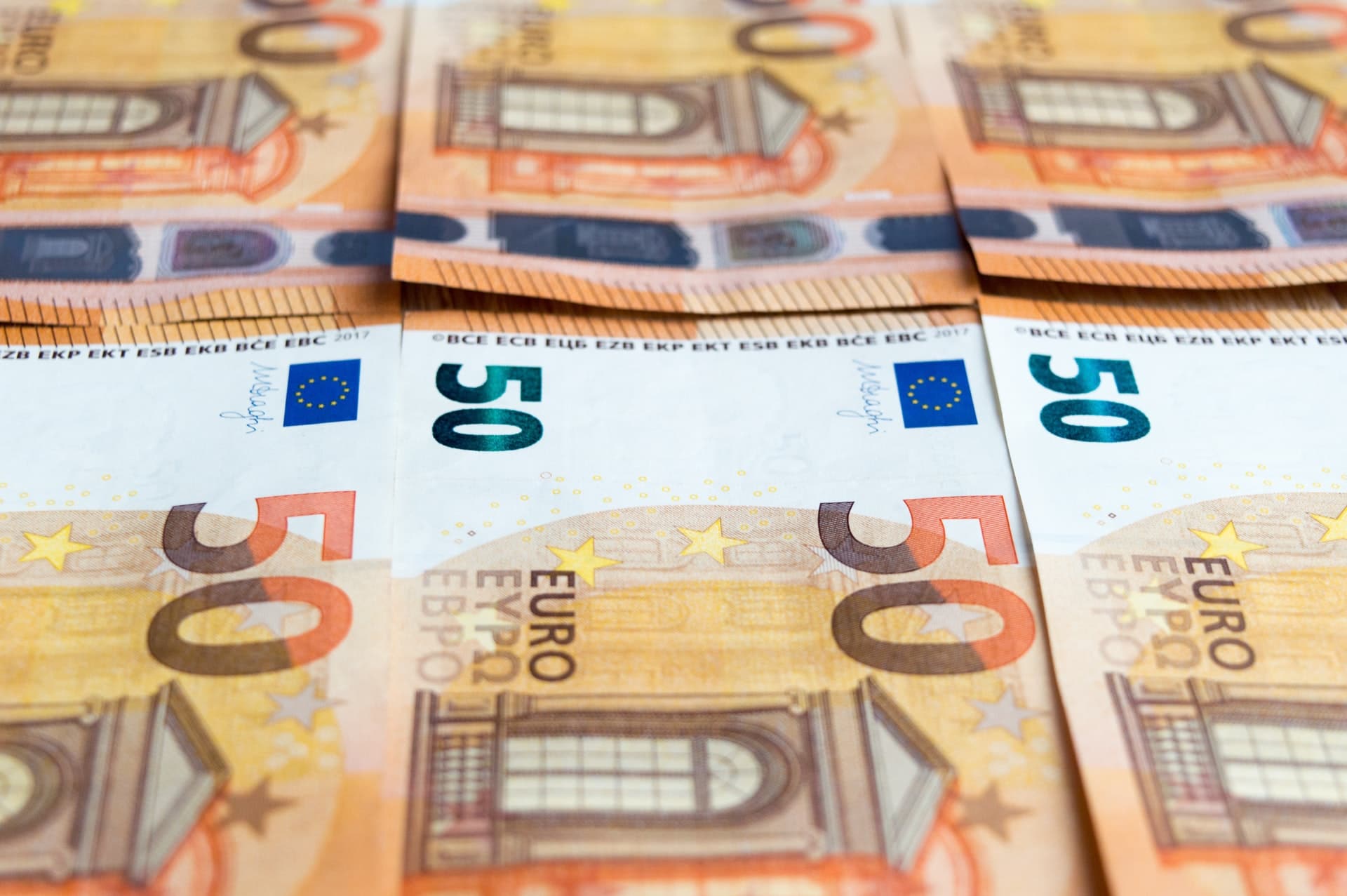 Sechs fünfzig Euro Scheine liegen auf einem Tisch nebeneinander.