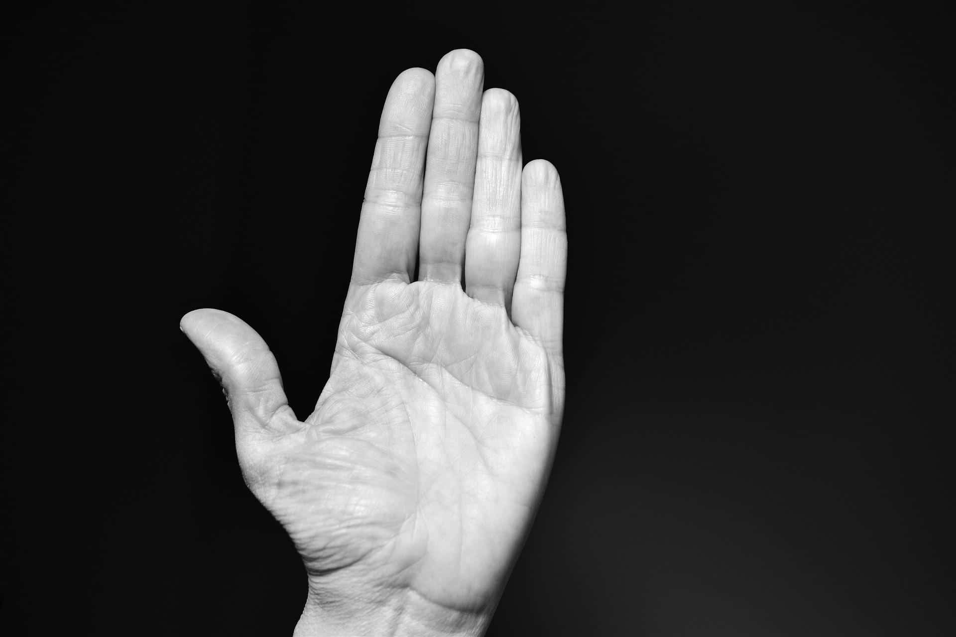 Ein schwarz-weiß Bild einer weißen Hand auf schwarzem Hintergrund.
