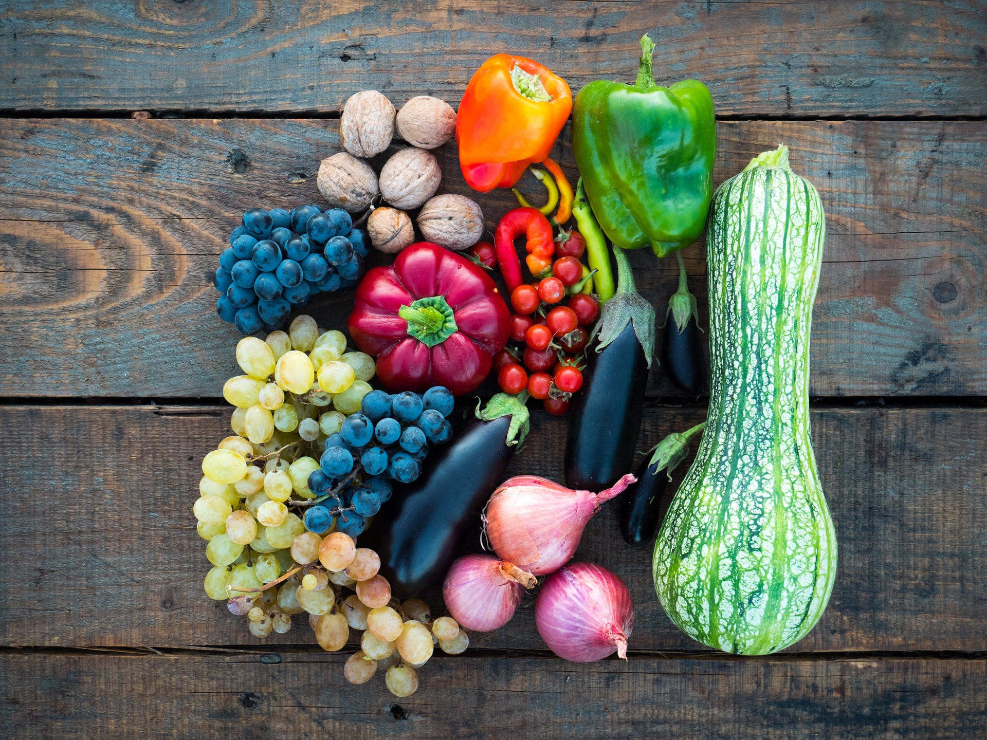 Buntes Gemüse und Obst liegt auf hölzernem Untergrund