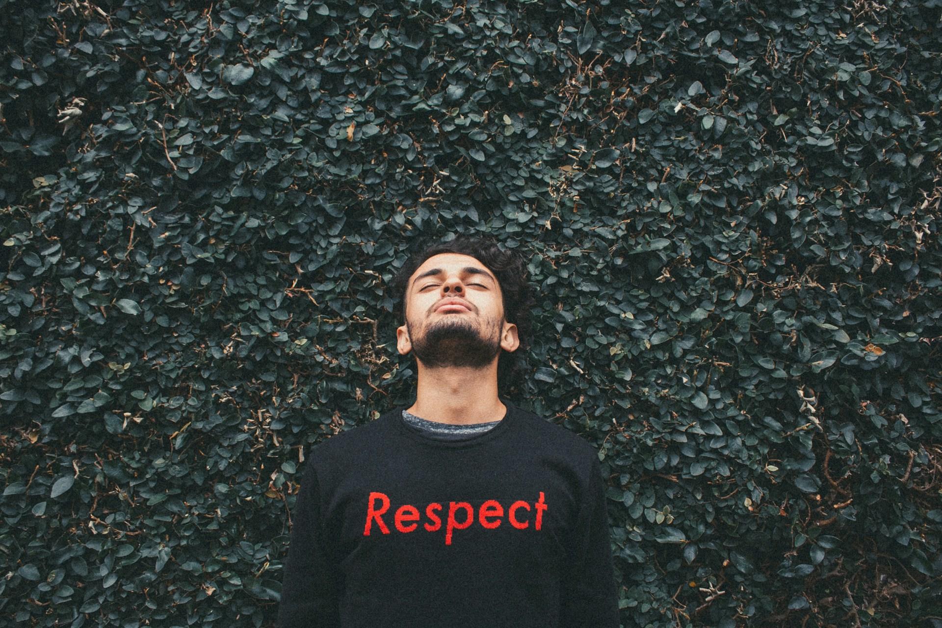 Mann mit Shirt auf dem Respekt steht