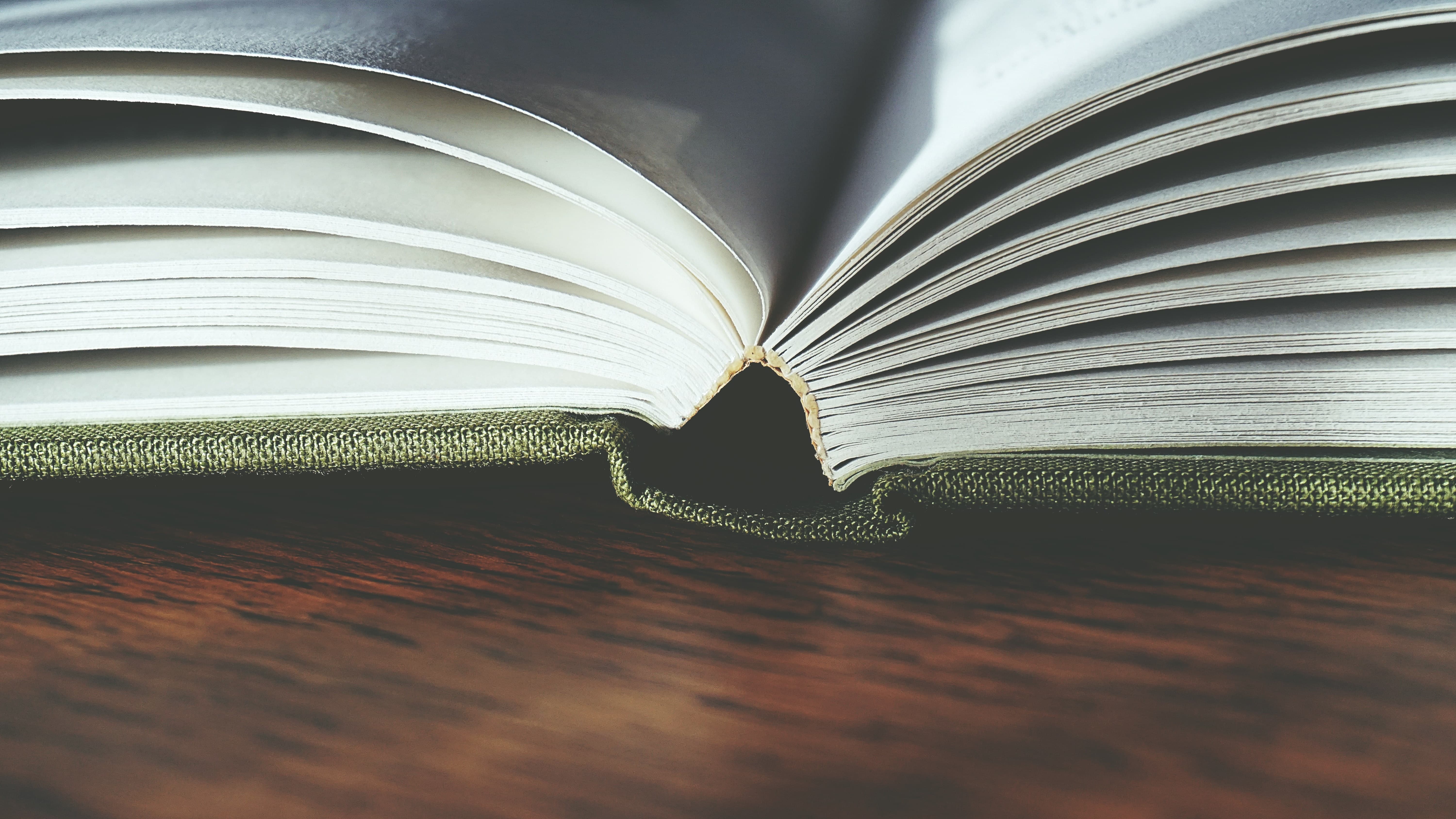 Aufgeschlagenes Buch liegt auf Holztisch