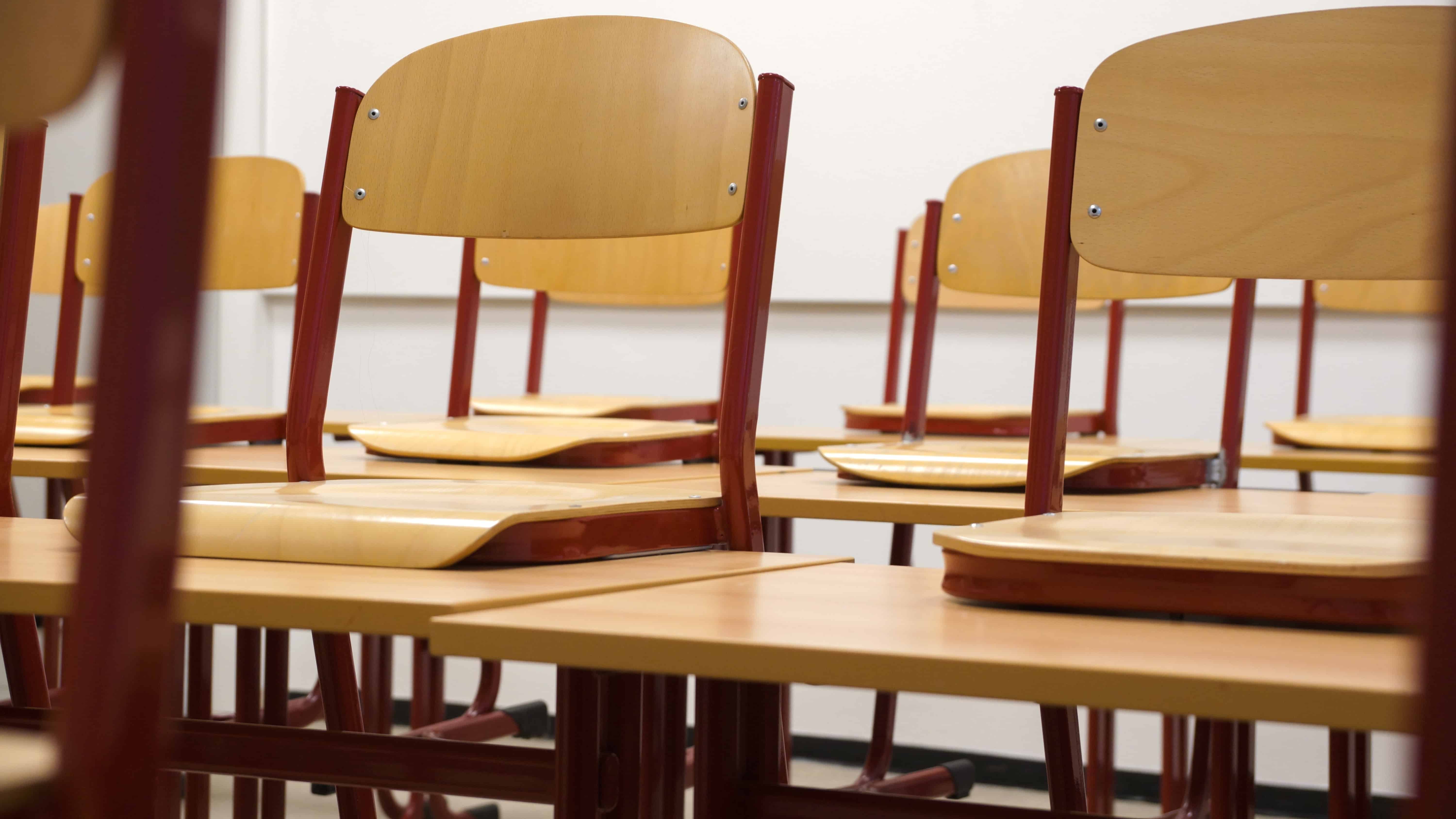 Hellbraune Stühle sind in Klasse auf Bänke gestellt