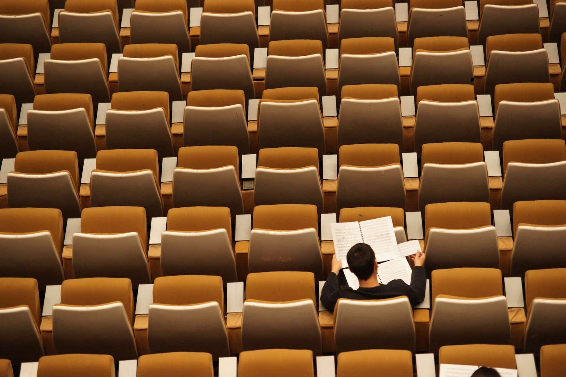 Student sitzt alleine in Hörsaal und lernt