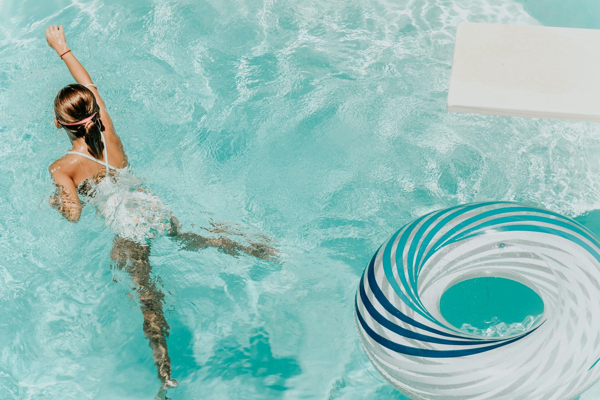 Mädchen mit Schwimmreifen im Wasser.