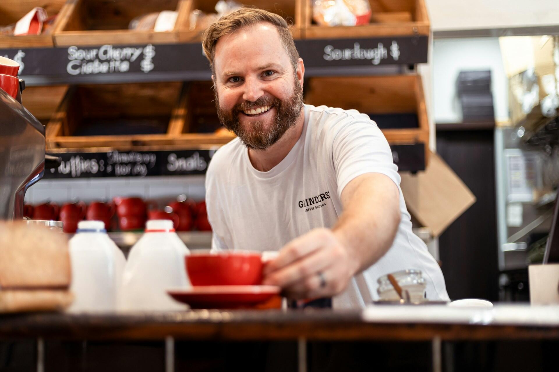 Mann serviert Cafe. |Quelle: Snappr